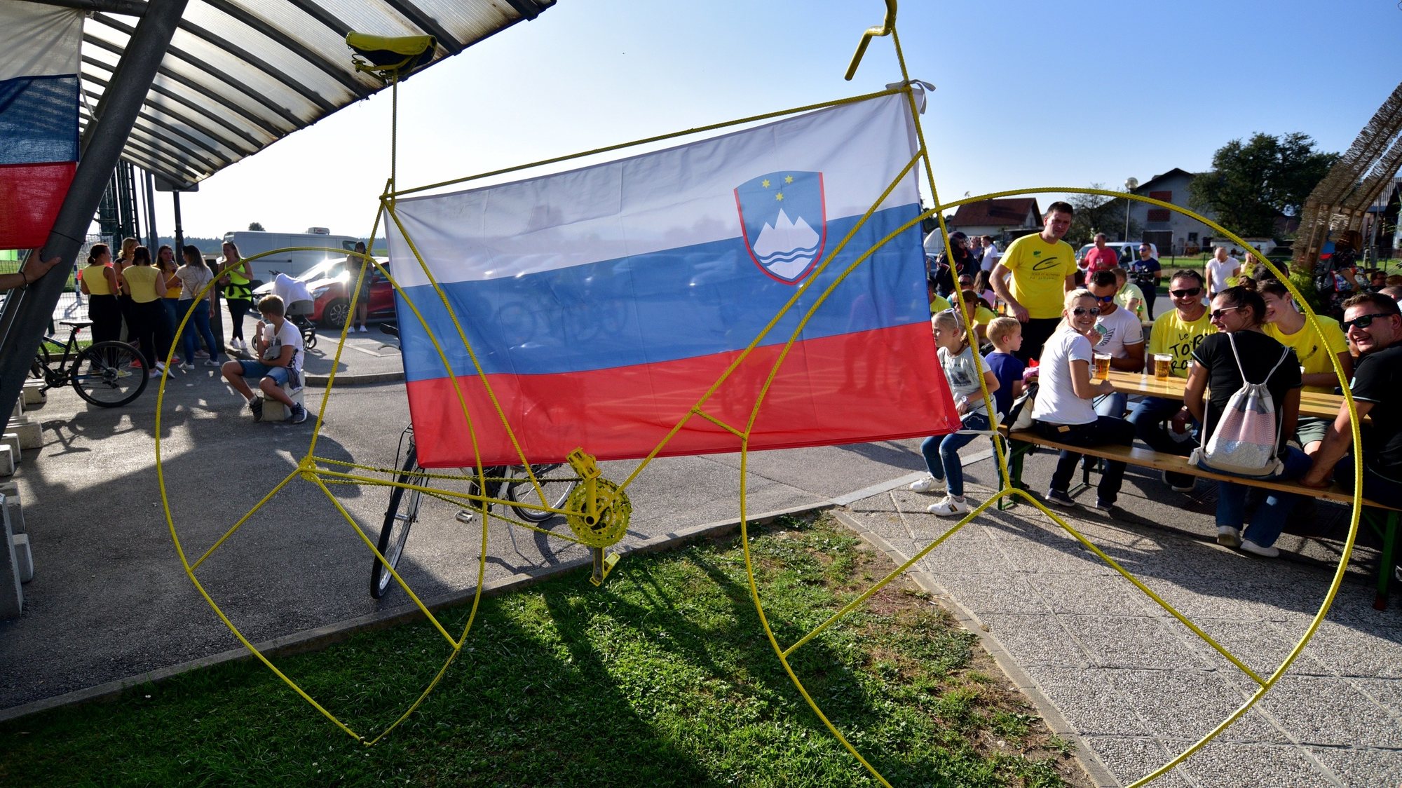 epa08684244 A yellow bike with the Slovenian flag as locals watch the broadcast of the 21st and last stage of the 2020 Tour de France cycling race, in Komenda, Slovenia, 20 September 2020. The village is the home town of cyclist Tadej Pogacar who wears the overall leader&#039;s yellow jersey before the last stage.  EPA/IGOR KUPLJENIK