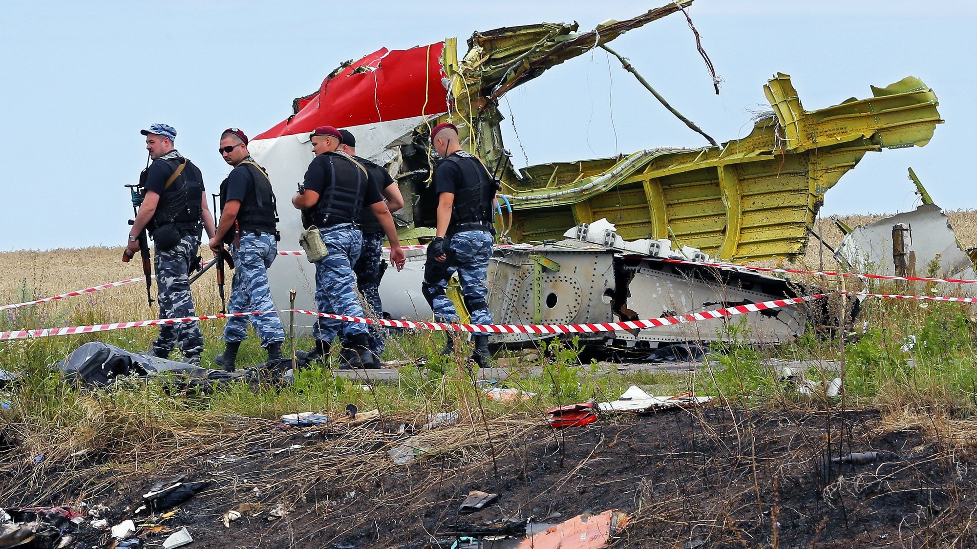 epa08255990  (FILE) - Armed rebel soldiers pass in front of a big piece of debris at the main crash site of the Boeing 777 Malaysia Airlines flight MH17, which crashed while flying over the eastern Ukraine region, near Grabovo, some 100 kilometers east from Donetsk, Ukraine, 19 July 2014. 
The District Court in The Hague on 09 March 2020 is due to start a trial against four people believed of being involved in the shooting down of a civil Boeing 777 plane over Ukraine on 17 July 2014. Dutch prosecutors charge three people with Russian citizenship and a Ukrainian national over the downing of Malaysia Airlines Flight MH17 from Amsterdam to Kuala Lumpur in which 283 passengers and 15 crew members on board were killed. Most of the victims were Dutch, Malaysian and Australian nationals. A Joint Investigation Team (JIT) from Belgium, Ukraine, Australia and Malaysia in their report came to the conclusion that a Russian-made BUK missile that hit the plane was fired from territory controlled by pro-Russian rebels. Russia has denied any responsibility for the downing and blamed Ukraine for the tragedy. It is not expected that the four accused will attend the trial as Russian law would prohibit their extradition.  EPA/ROBERT GHEMENT *** Local Caption *** 51488376