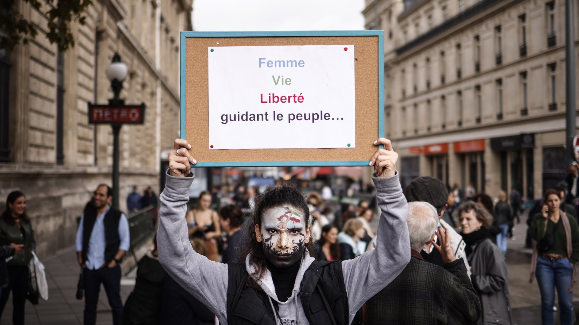 epa10219689 A woman with her face painted holds a sign reading &#039;Women, Life, Liberty&#039; during a rally in support of Iranian women in Paris, France, 02 October 2022. This demonstration takes place following the deaths of Mahsa Amini, who died while in police custody after being detained by Iran&#039;s morality police, and Hadis Najafi, who was shot during a protest in Iran.  EPA/YOAN VALAT