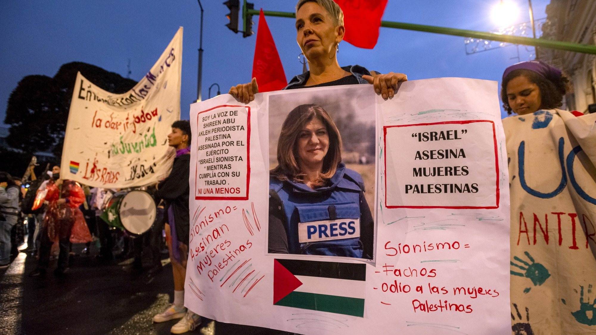 epaselect epa10329160 A woman holds a sign with a picture of slain Palestinian-American journalist Shireen Abu Akleh during a march on the International Day for the Elimination of Violence Against Women, in San Jose, Costa Rica, 25 November 2022.  EPA/Alexander OTAROLA
