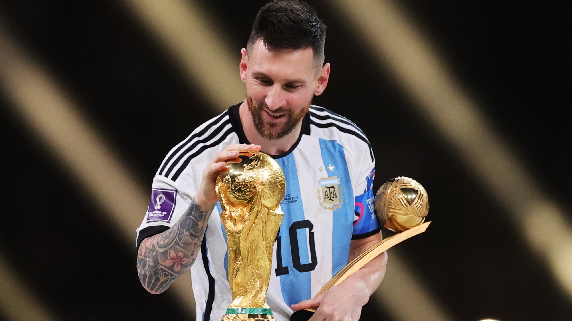 epaselect epa10373265 Lionel Messi of Argentina touches the World Cup trophy as he passes it after winning the golden ball award during the awards ceremony after the FIFA World Cup 2022 Final between Argentina and France at Lusail stadium, Lusail, Qatar, 18 December 2022.  EPA/Friedemann Vogel