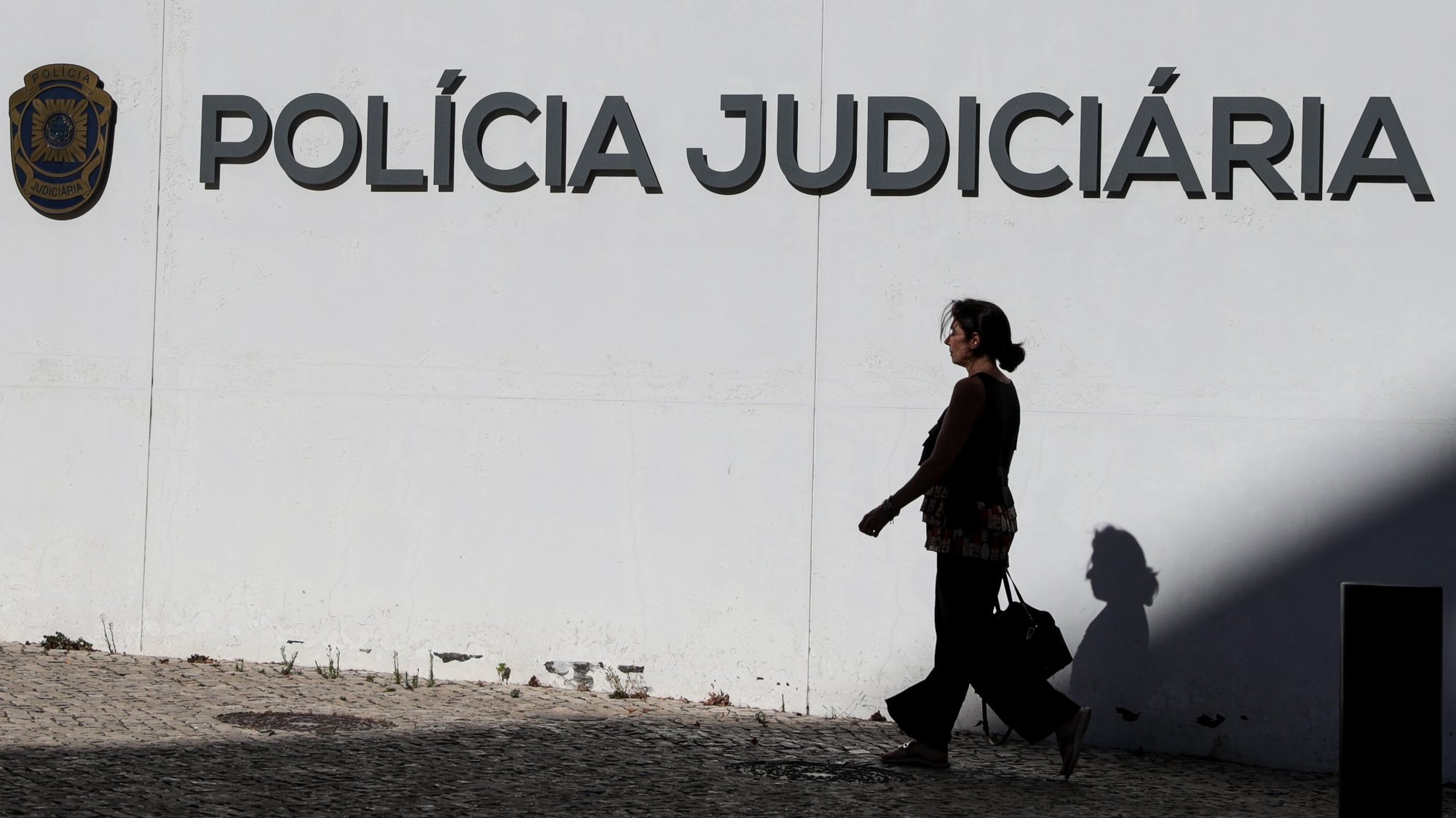 Uma traseunte passa pelo edificio sede da Policia Judiciária em Lisboa, 17 de agosto de 2022. TIAGO PETINGA/LUSA