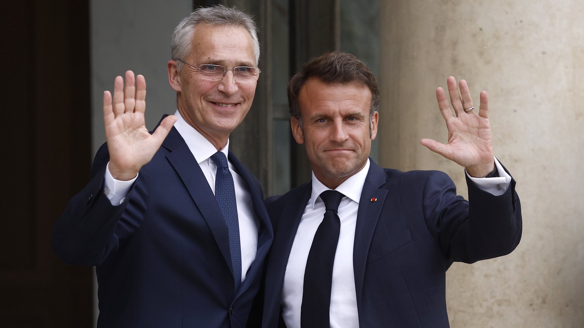 epa10715771 French President Emmanuel Macron (R) and NATO Secretary General Jens Stoltenberg (L) wave upon their meeting at the Elysee Palace in Paris, France, 28 June 2023. Their meeting takes place as part of preparations for the upcoming NATO Summit in Vilnius between 11 and 12 July.  EPA/YOAN VALAT