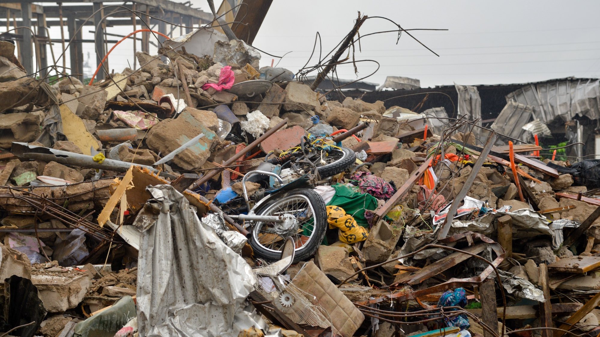 epa10766441 A motorcycle sits on piles of rubble after a building collapsed in Douala, Cameroon, 24 July 2023. A four-storey residential building collapsed onto a one-storey house in the early hours of 23 July 2023.  EPA/DONGMO RODRIGUE WILLIAM