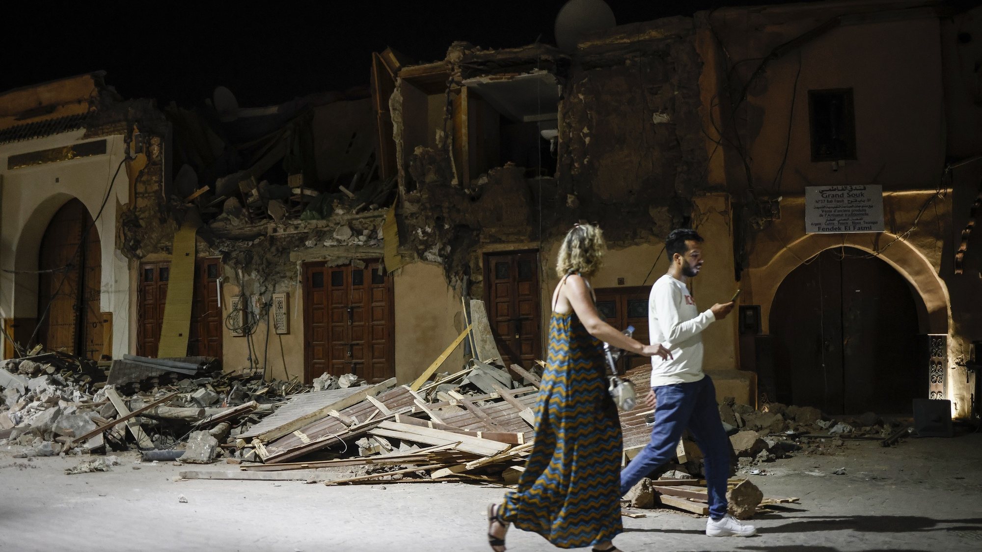 epaselect epa10851787 People pass by a damaged house in the old town of Marrakech, Morocco, 10 September 2023. A powerful earthquake that hit central Morocco late 08 September, killed 1,037 people and injured more than 1,200 others, the country&#039;s Interior Ministry announced on 09 September cited by public television. The earthquake, measuring magnitude 6.8 according to the USGS, damaged buildings from villages and towns in the Atlas Mountains to Marrakesh.  EPA/YOAN VALAT