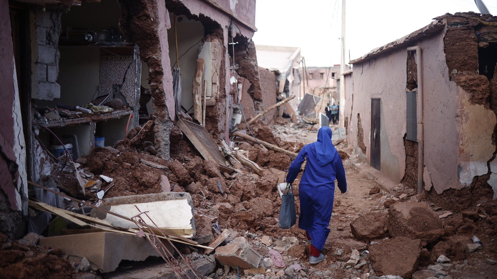 epa10853311 A woman passes by damaged buildings following a powerful earthquake in Ouirgane, south of Marrakesh, Morocco, 10 September 2023. A magnitude 6.8 earthquake that struck central Morocco late 08 September has killed at least 2,012 people and injured 2,059 others, 1,404 of whom are in serious condition, damaging buildings from villages and towns in the Atlas Mountains to Marrakesh, according to a report released by the country&#039;s Interior Ministry. The earthquake has affected more than 300,000 people in Marrakesh and its outskirts, the UN Office for the Coordination of Humanitarian Affairs (OCHA) said.  EPA/YOAN VALAT