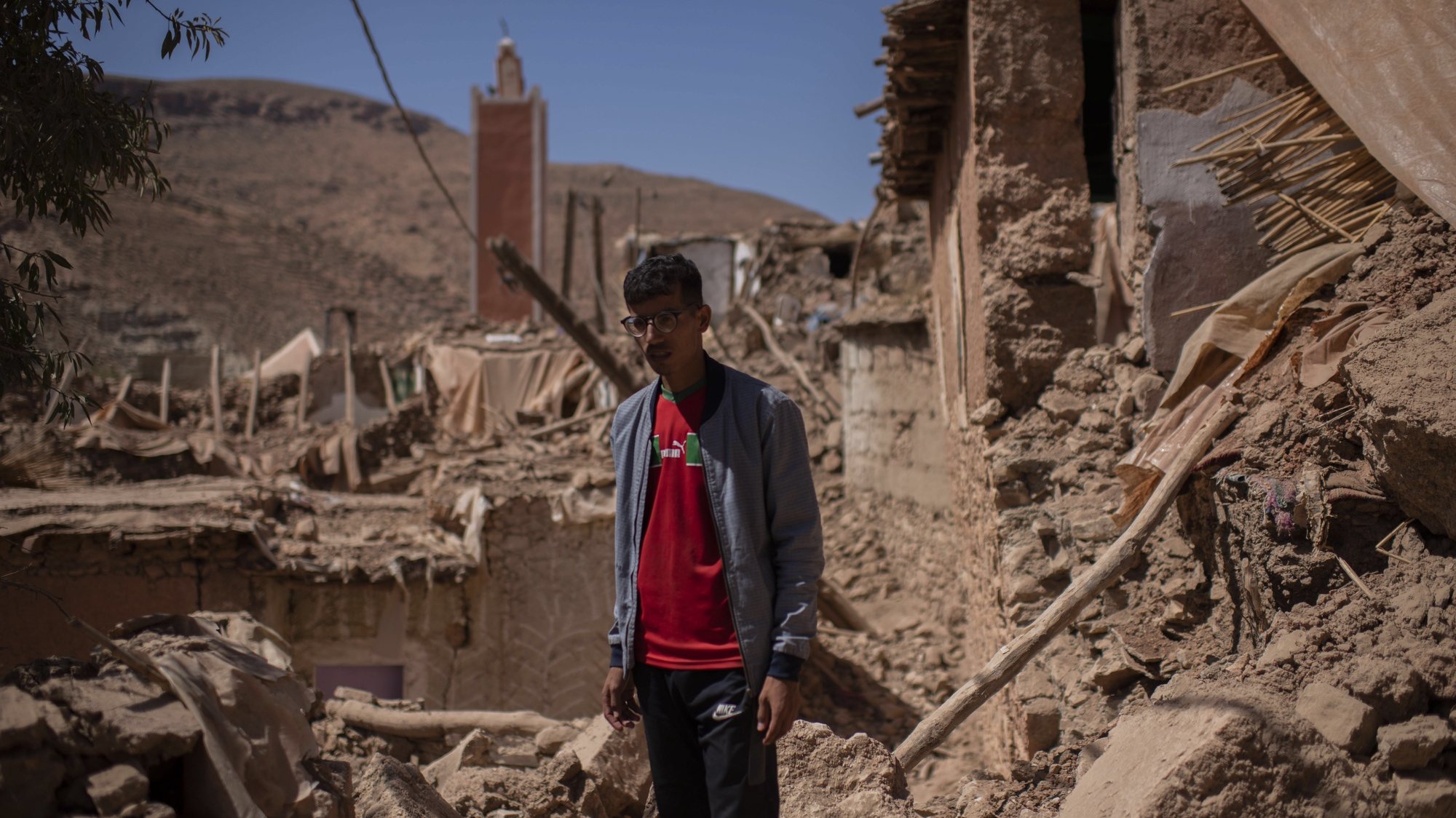 epa10860804 An earthquake survivor poses in front of devastation in the village in Takhit village, Chichaoua province, Morocco, 14 September 2023. The 6.8-magnitude earthquake struck central Morocco late September 08, killing nearly 3,000 people and damaging buildings from villages and towns in the Atlas Mountains to Marrakesh, according to a report issued by the country&#039;s Ministry of Interior.  EPA/Jalal Morchidi