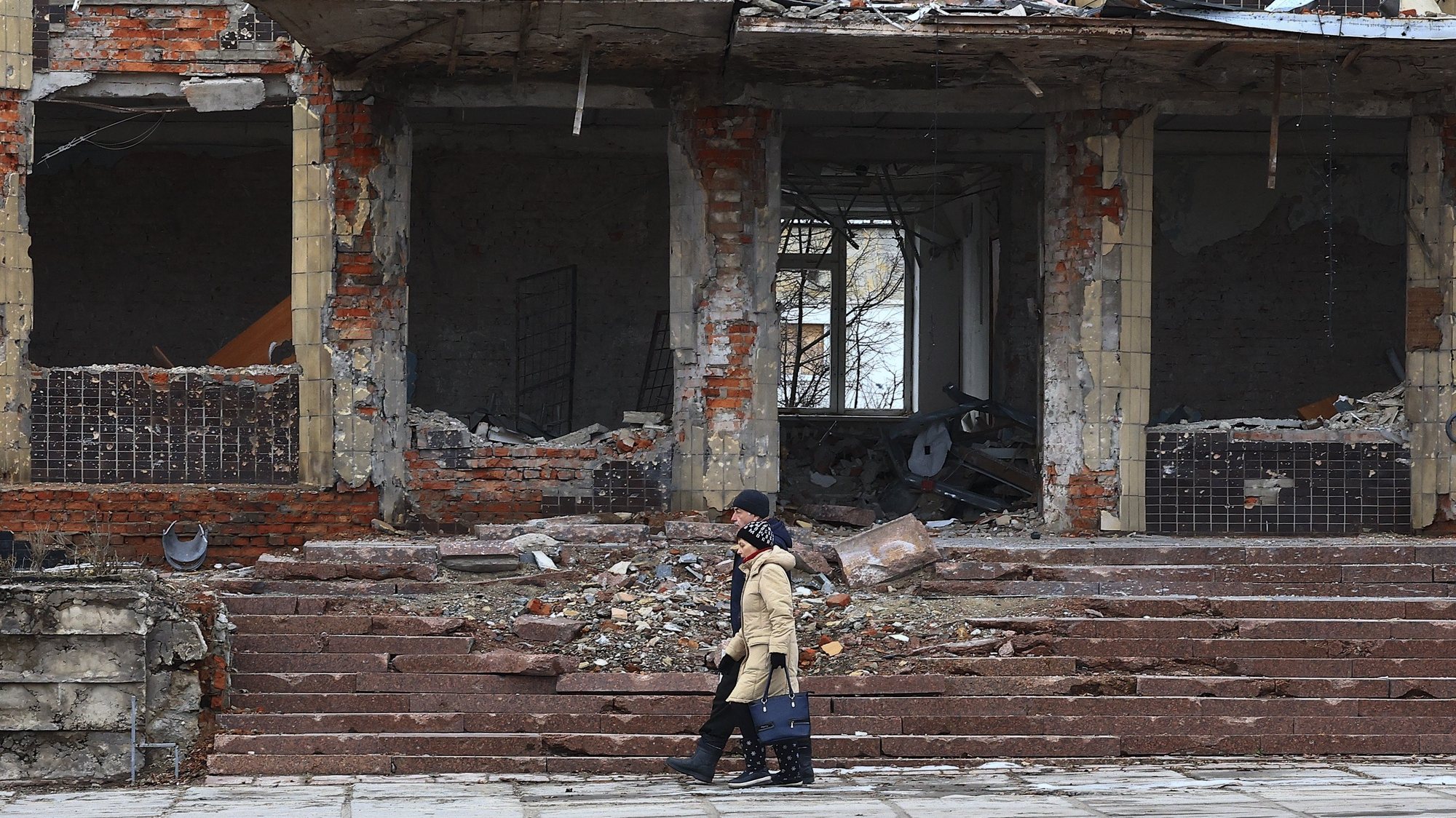 epa11137550 A couple walks near the rubble of destroyed buildings in Kupiansk, Kharkiv region, Ukraine, 08 February 2024, amid the Russian invasion. According to Ukrainian officials, Russian forces have been intensifying their offensive in the Kupiansk area of the front for more than six months as they try to regain control of the city since 2022, when Ukrainian forces recaptured control of the area in the Kharkiv counteroffensive.  EPA/ANTONIO COTRIM