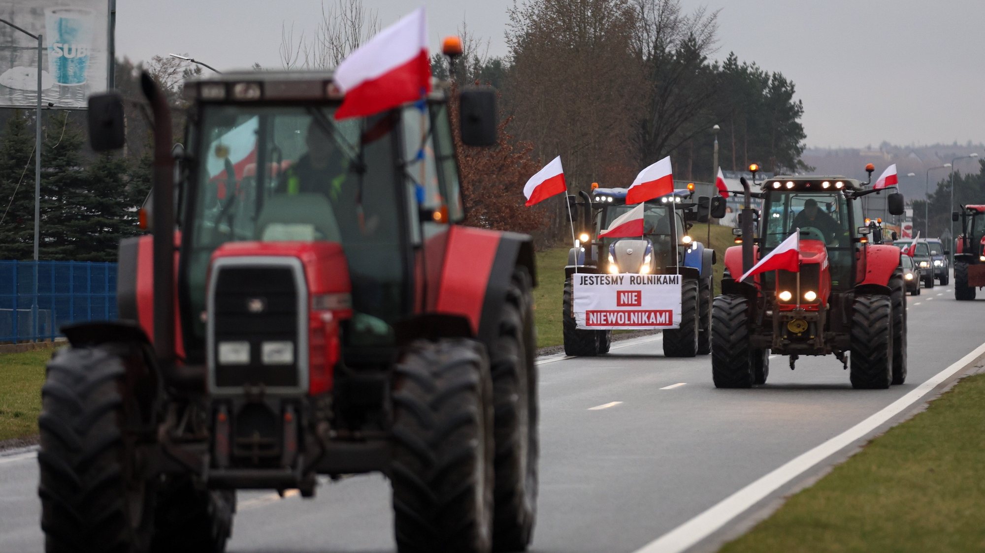 epa11175164 Farmers with their tractors and a banner &#039;We are Farmers not slaves&#039; protest on the access road to Katowice Airport, south Poland, 23 February 2024. Farmers from all over Poland are continuing their protests. Farmers from all over Poland are continuing their protests against the EU&#039;s agricultural policy, the Green Deal for Europe, excessive bureaucracy and unfair imports of cheaper products from Ukraine.  EPA/MICHAL MEISSNER  POLAND OUT