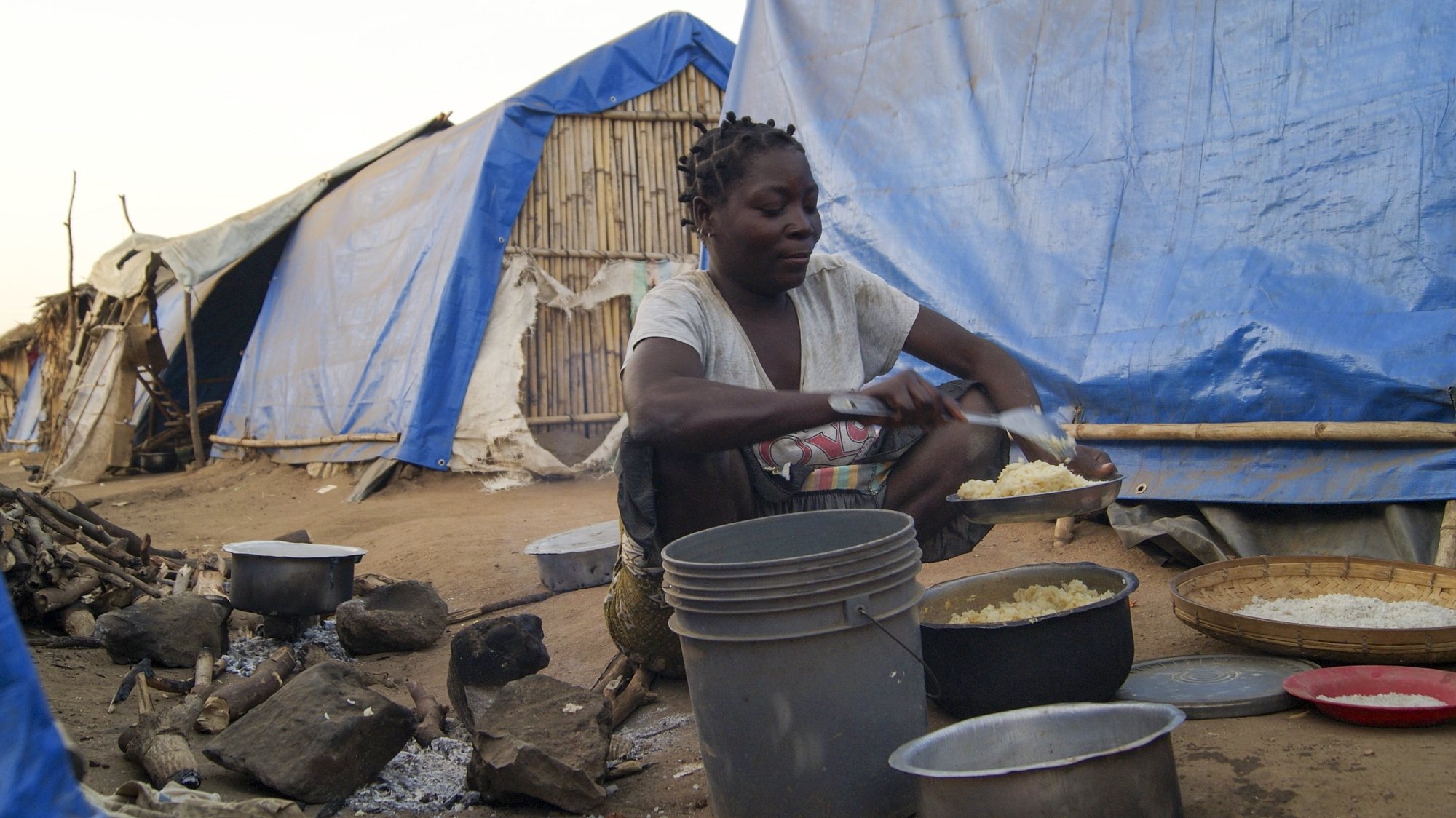 A woman prepares a meal in one of the shelter camps in Metuge, a space housing displaced people fleeing armed violence in northern Mozambique. Cabo Delgado, Mozambique, 16 August 2021 (issue on 17 August 2021). Following the attacks, which have terrorized Cabo Delgado province since 2017, there are more than 3,100 deaths, according to the ACLED conflict registration project, and more than 817,000 displaced people, according to Mozambican authorities. LUISA NHANTUMBO/LUSA