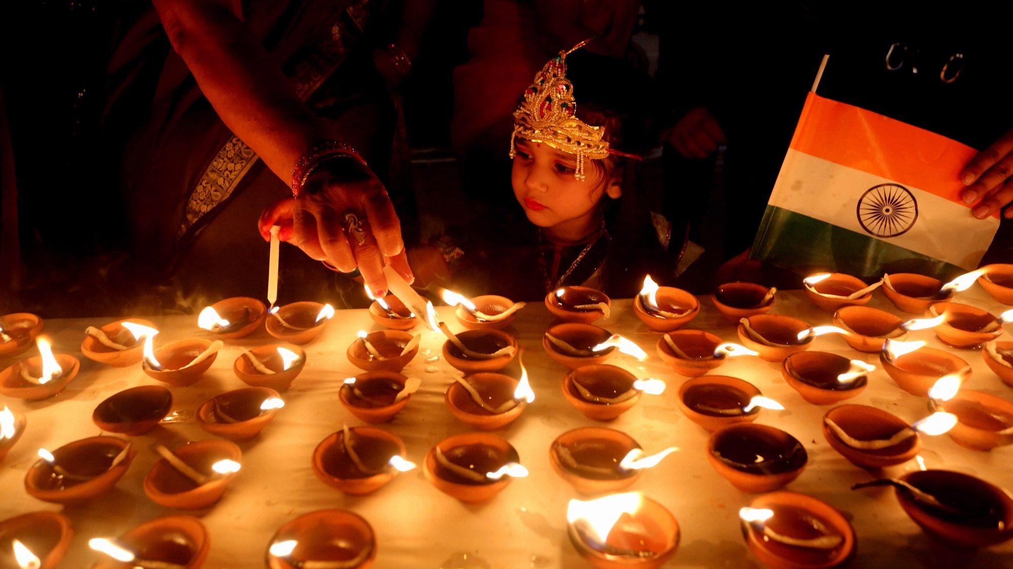 epa08818524 Indian people light lamps at a temple on the occasion of Diwali, or the Festival of Lights, in Bhopal, India, 13 November 2020. The Diwali festival celebrates the victory of good over evil and commemorates Lord Ram&#039;s return to his kingdom Ayodhya after a 14-year exile. Diwali will be celebrated on 14 November 2020.  EPA/SANJEEV GUPTA
