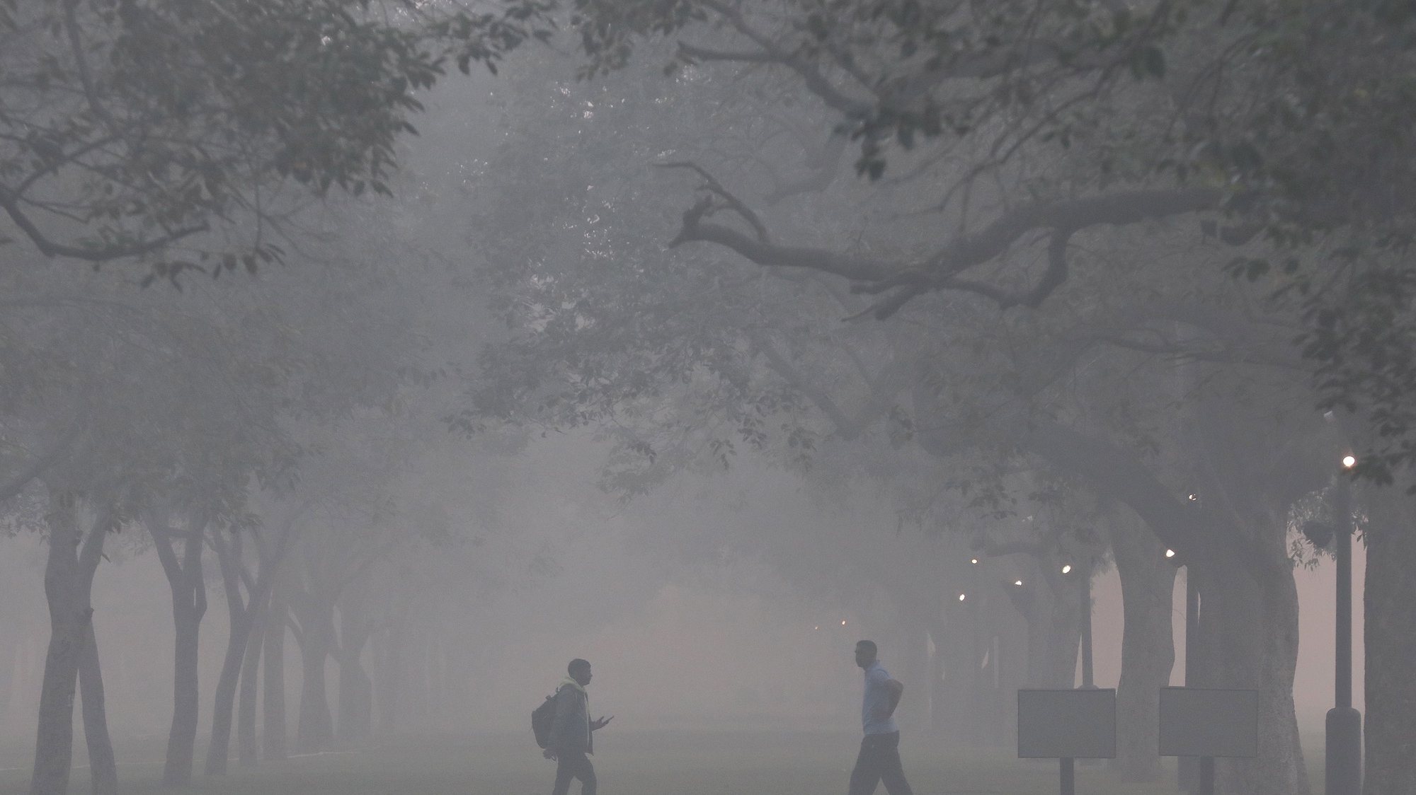 epa10283319 People walk as the city is engulfed in heavy smog near Rajpath, in New Delhi, India, 03 November 2022. Delhi and National Capital Region&#039;s air quality slipped into the &#039;Severe and Hazardous&#039; category as a result of stubble burning.  EPA/RAJAT GUPTA