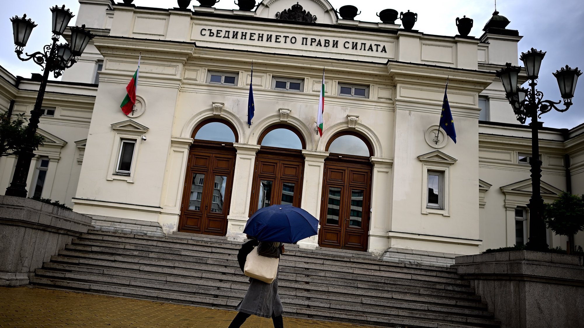 epa10220965 A woman with an umbrella walks in front of the Parliament building in Sofia, Bulgaria, 03 October 2022. GERB, Bulgaria&#039;s former Prime Minister Boyko Borissov&#039;s party is projected to win 02 October&#039;s election, as according to partial results, the centre-right party has received 25.4 percent of the votes.  EPA/VASSIL DONEV