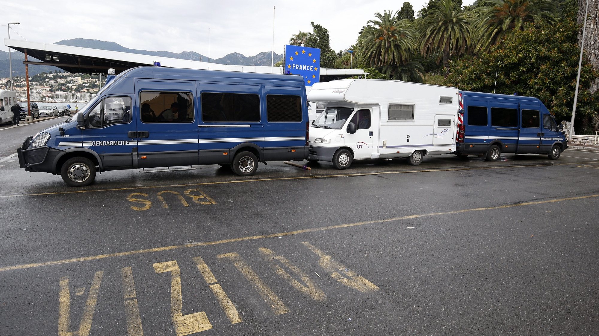 epa04798638 French police vehicles are parked to  block the French border against stranded migrants waiting to cross at the Franco-Italian border near Menton, southern France, 14 June 2015. More than 150 migrants who wished to cross the border have been blocked by the French and Italian police. The European Commission proposed in late May that 40,000 asylum seekers be relocated from Italy and Greece over two years. The plan foresees the largest groups of asylum seekers going to Germany and France, based on a calculation involving EU countries&#039; population sizes, unemployment rates, wealth and existing refugee intake rates.  EPA/SEBASTIEN NOGIER