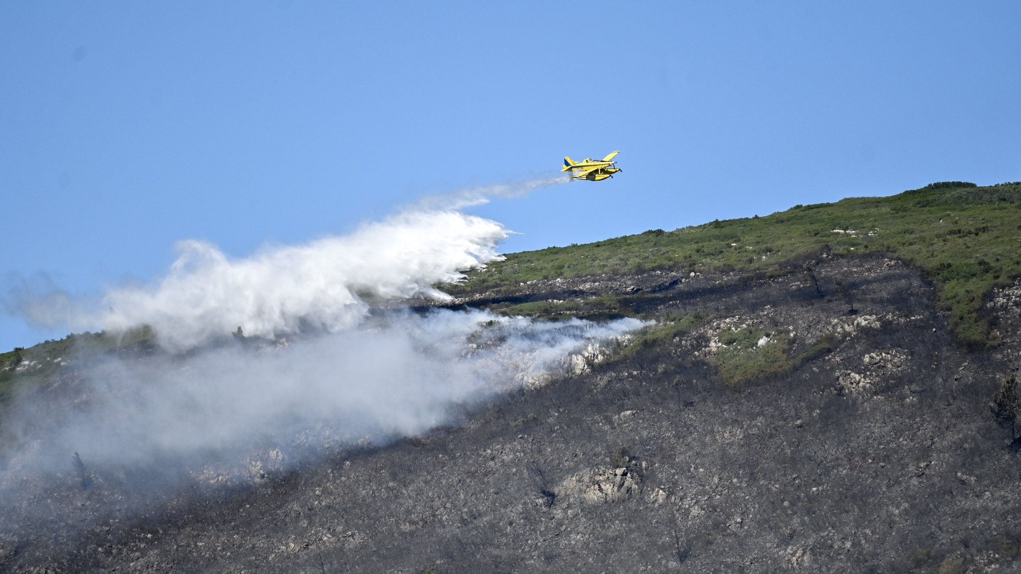 Uma aeronave combate o incêndio que deflagrou na quarta-feira na serra do Montejunto que mobiliza mais de 500 operacionais, no Cadaval, 13 de julho de 2023. CARLOS BARROSO/LUSA