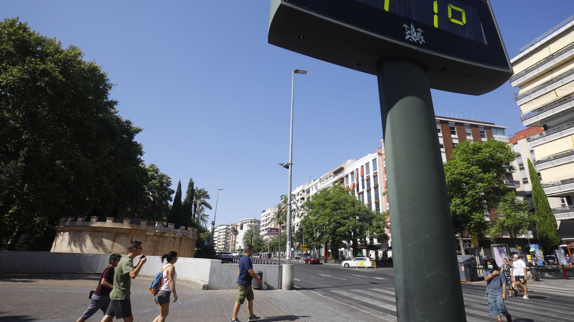 epa09407425 People walk next to a thermometer that displays the high temperatures reached in central Cordoba, Andalucia, southern Spain, 09 August 2021. A new heat wave is expected to reach Spain on the ongoing week to reach 45 degrees Celsius on some point of the South of the peninsula.  EPA/Salas