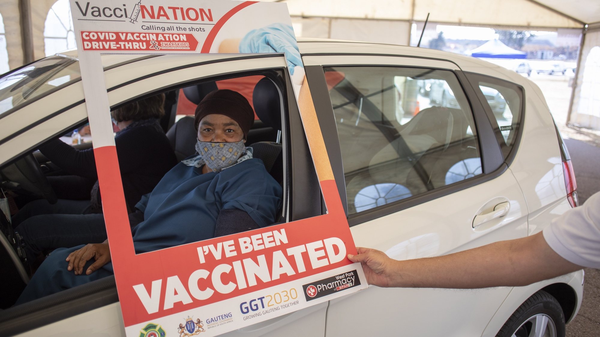 epa09418882 A person has her vaccine administered at a drive through Covid-19 coronavirus vaccination site at the Swartkops Raceway in Pretoria, South Africa, 18 August 2021. South Africa has to date vaccinated 17 percent of the population and is aiming at starting vaccinations for over 18 year olds in the next weeks.  EPA/KIM LUDBROOK