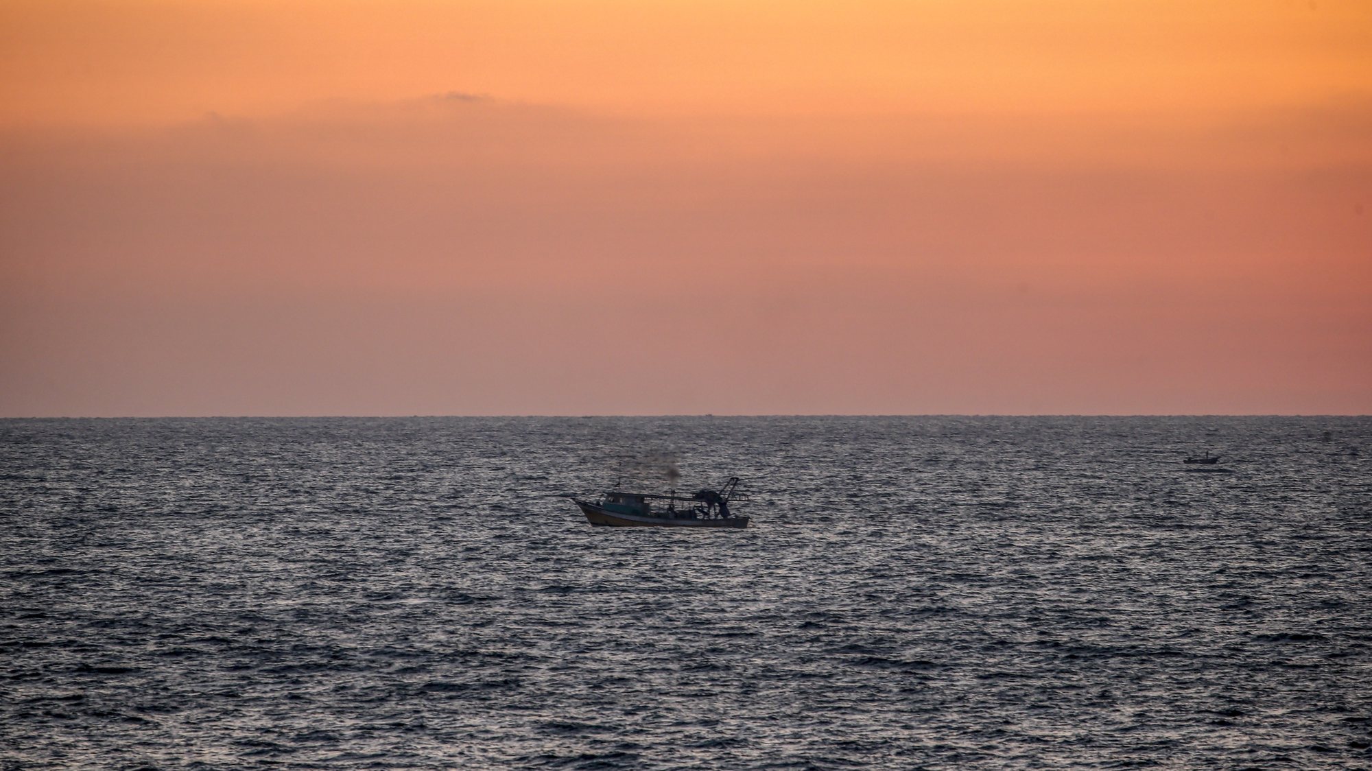 epa09296421 A Palestinian fishing boat sails at sea during sunset in Gaza City, 23 June 2021.  EPA/MOHAMMED SABER