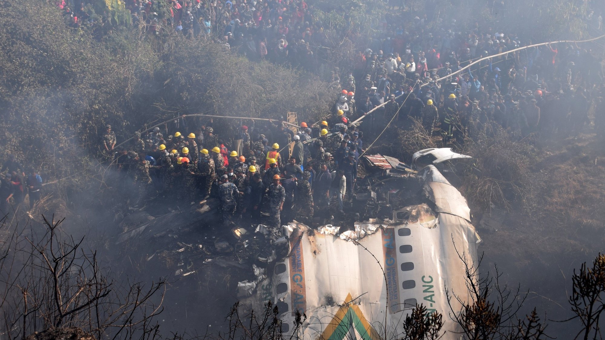 epaselect epa10406958 A general view of rescue teams working near the wreckage at the crash site of a Yeti Airlines ATR72 aircraft in Pokhara, central Nepal, 15 January 2023. A Yeti Airlines ATR72 aircraft carrying 72 people on board, 68 passengers and 4 crew members, crashed into a gorge while trying to land at the Pokhara International Airport. According to a statement from the Civil Aviation Authority of Nepal (CAAN), at least 68 people were confirmed dead.  EPA/KRISHNA MANI BARAL