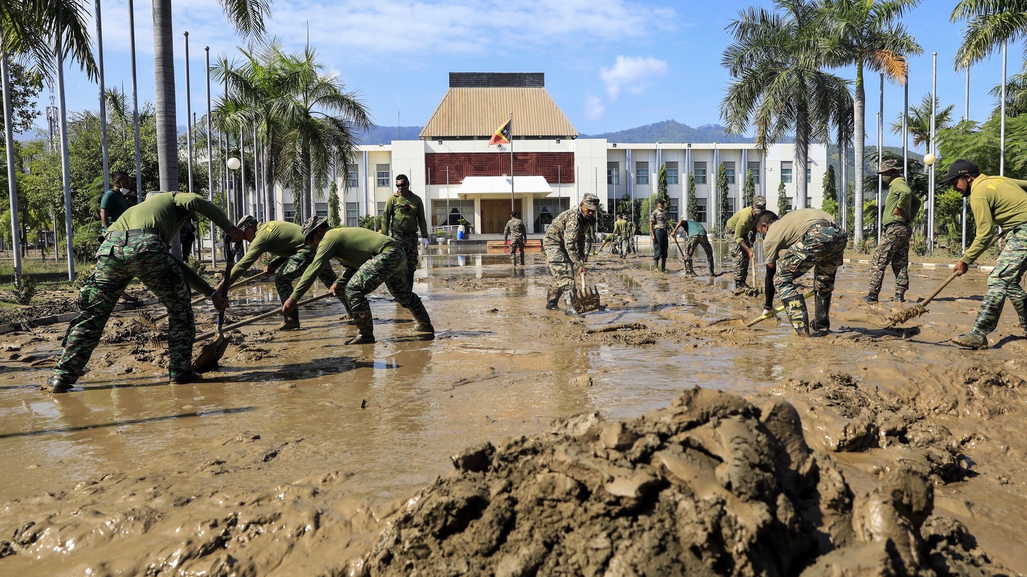 Os militares de Timor-Leste limpam a lama perto do gabinete presidencial, que foi afetado pelas cheias do país