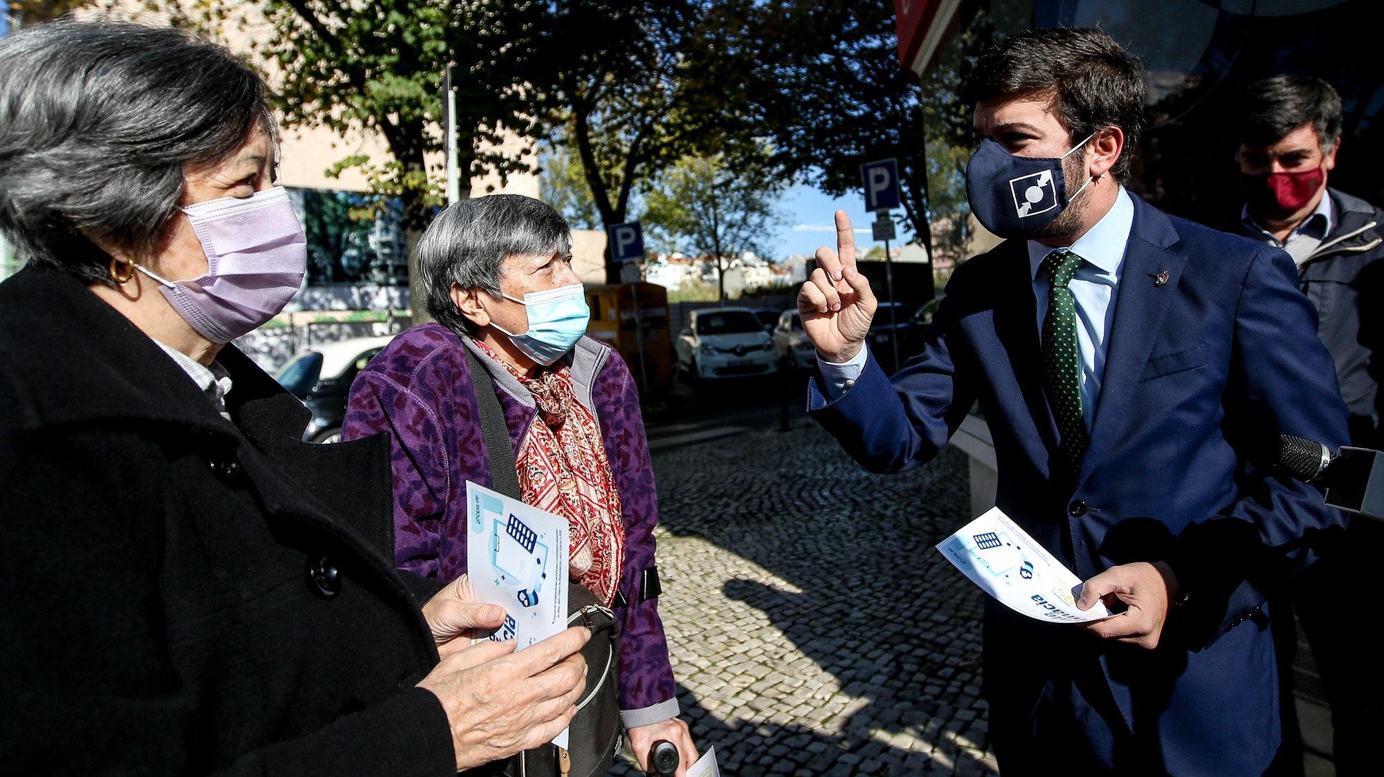 O presidente do CDS-PP, Francisco Rodrigues dos Santos (2-D), conversa com populares á porta de uma farmácia, durante a ação de esclarecimento sobre o Vale Farmácia, em Lisboa, 23 de novembro de 2020. NUNO FOX/LUSA