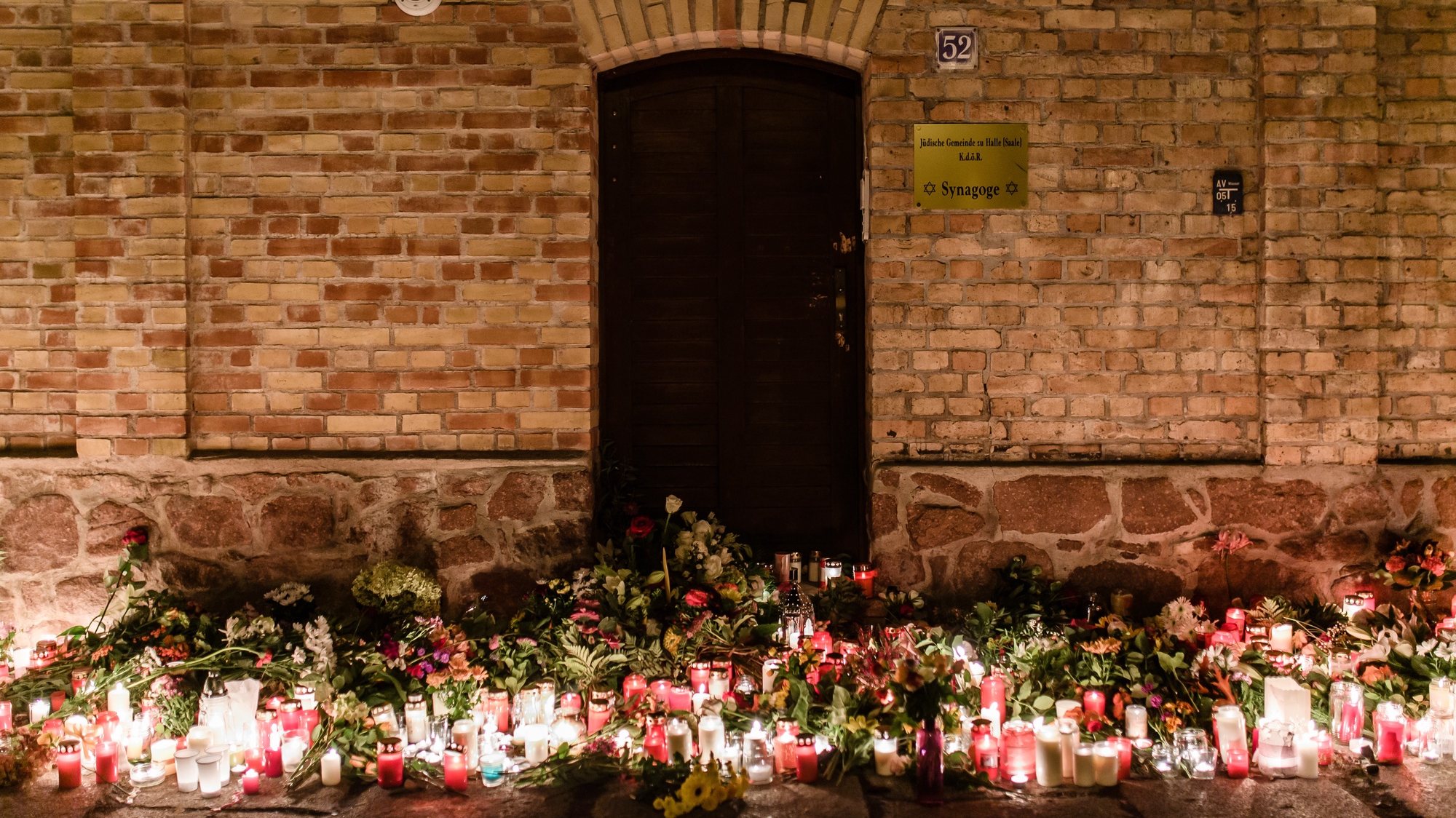 epa08891360 (FILE) - Candles and flowers are laid in front of the synagogue after an attack in which a man went on rampage shooting and tried to enter the Halle synagogue during celebrations of Yom Kippur, in Halle Saale, Germany, 10 October 2019 (reissued 18 December 2020). The trial of the Halle syangogue shooting is expected to end on 21 December.  EPA/CLEMENS BILAN *** Local Caption *** 55538431