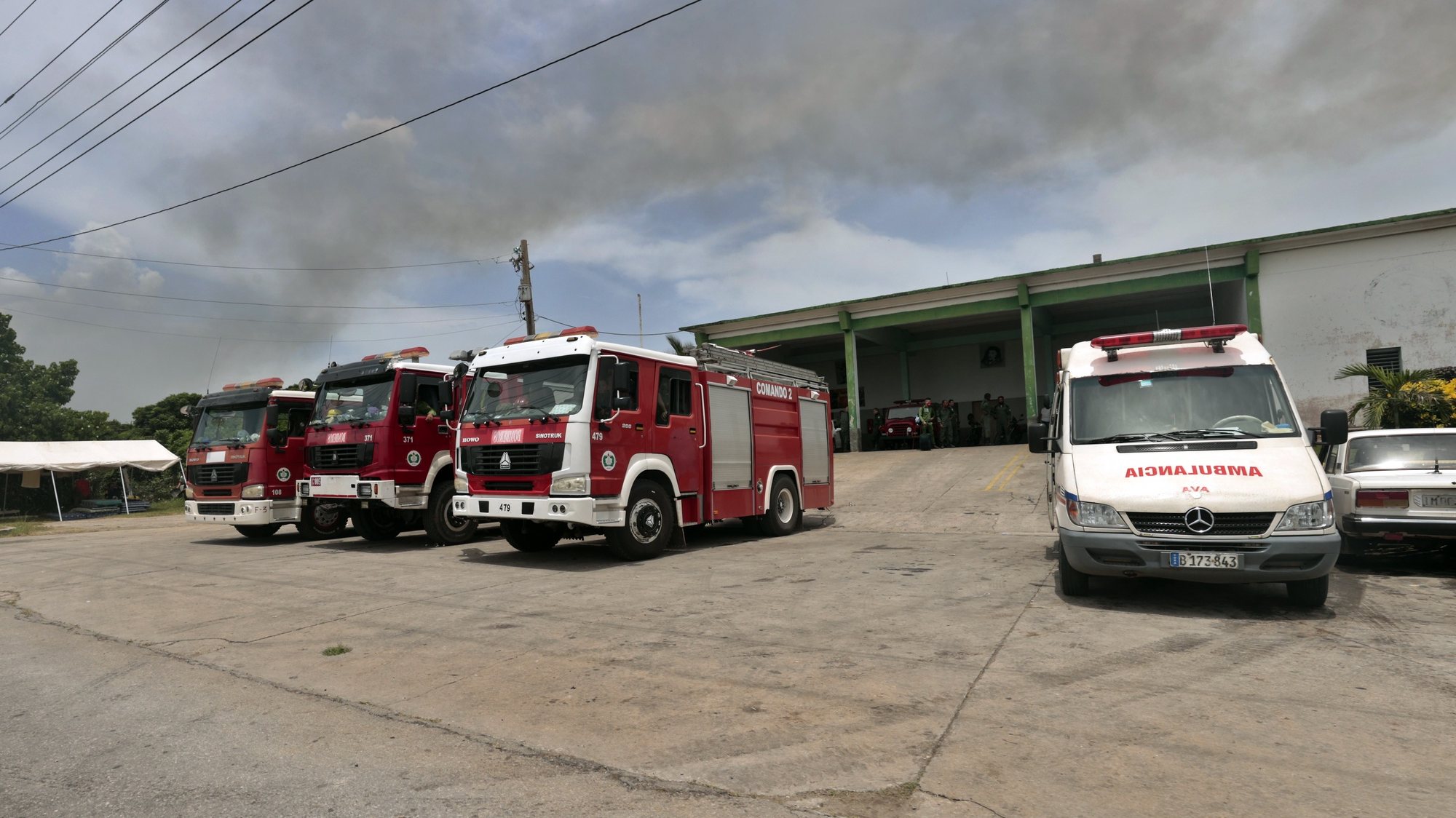 epa10114784 Several fire trucks and ambulances are seen in the industrial zone of the port in Matanzas, Cuba, 10 August 2022. The Cuban authorities declared this Wednesday the fire that has affected a base of fuel depots in Matanzas (west), the largest industrial fire in the country&#039;s history, under control.  EPA/Ernesto Mastrascusa