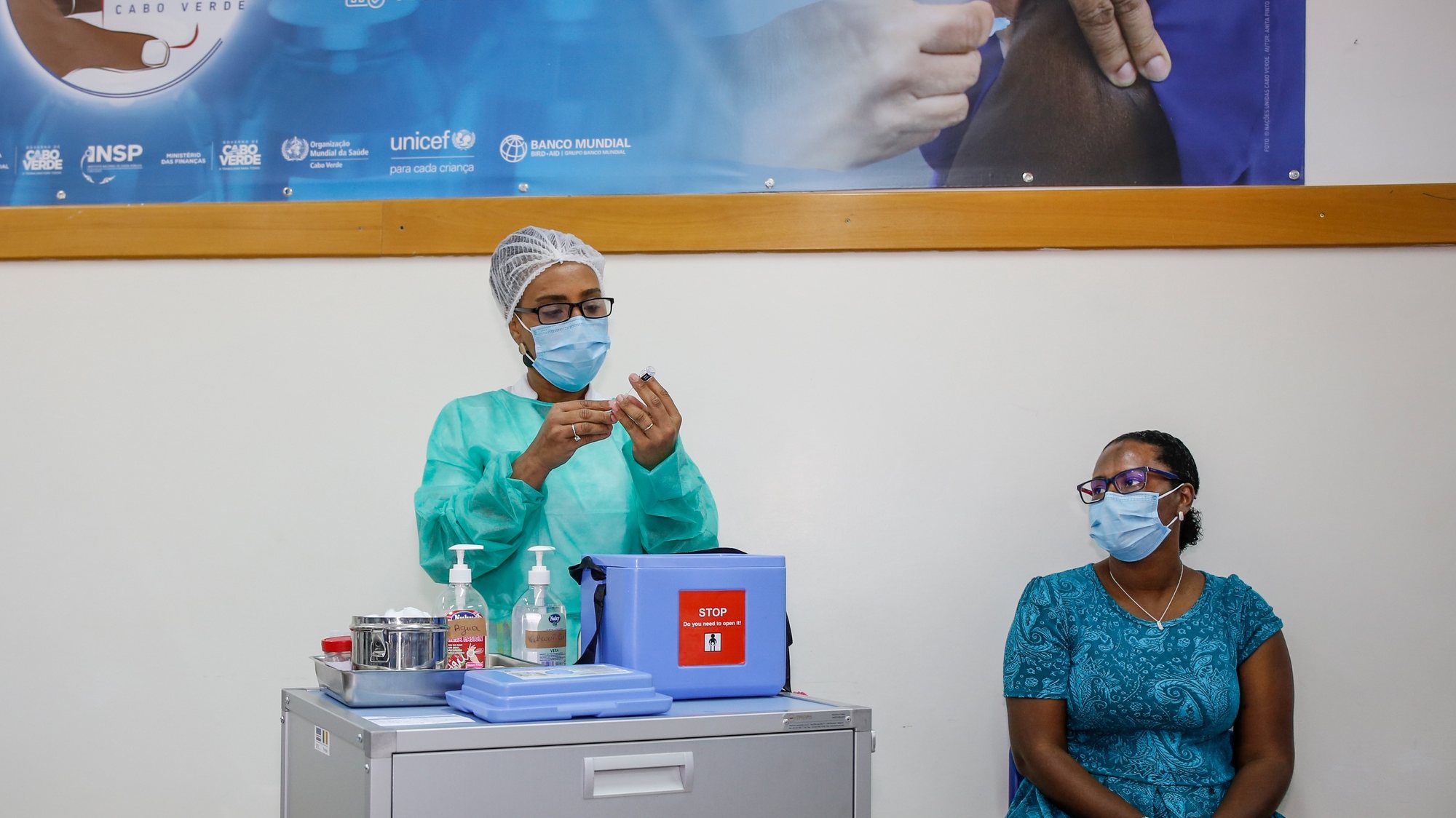 Uma profissional de saúde administra a vacina da Pfizer a covid-19 a um dos seis profissionais de saúde da Praia, antecedendo o início da campanha de vacinação em Cabo Verde, sexta-feira, precisamente um ano depois da chegada da pandemia ao arquipélago, no Centro de Saúde da Achada de Santo António, na Praia, Cabo Verde, 18 de março de 2021. FERNANDO DE PINA/LUSA