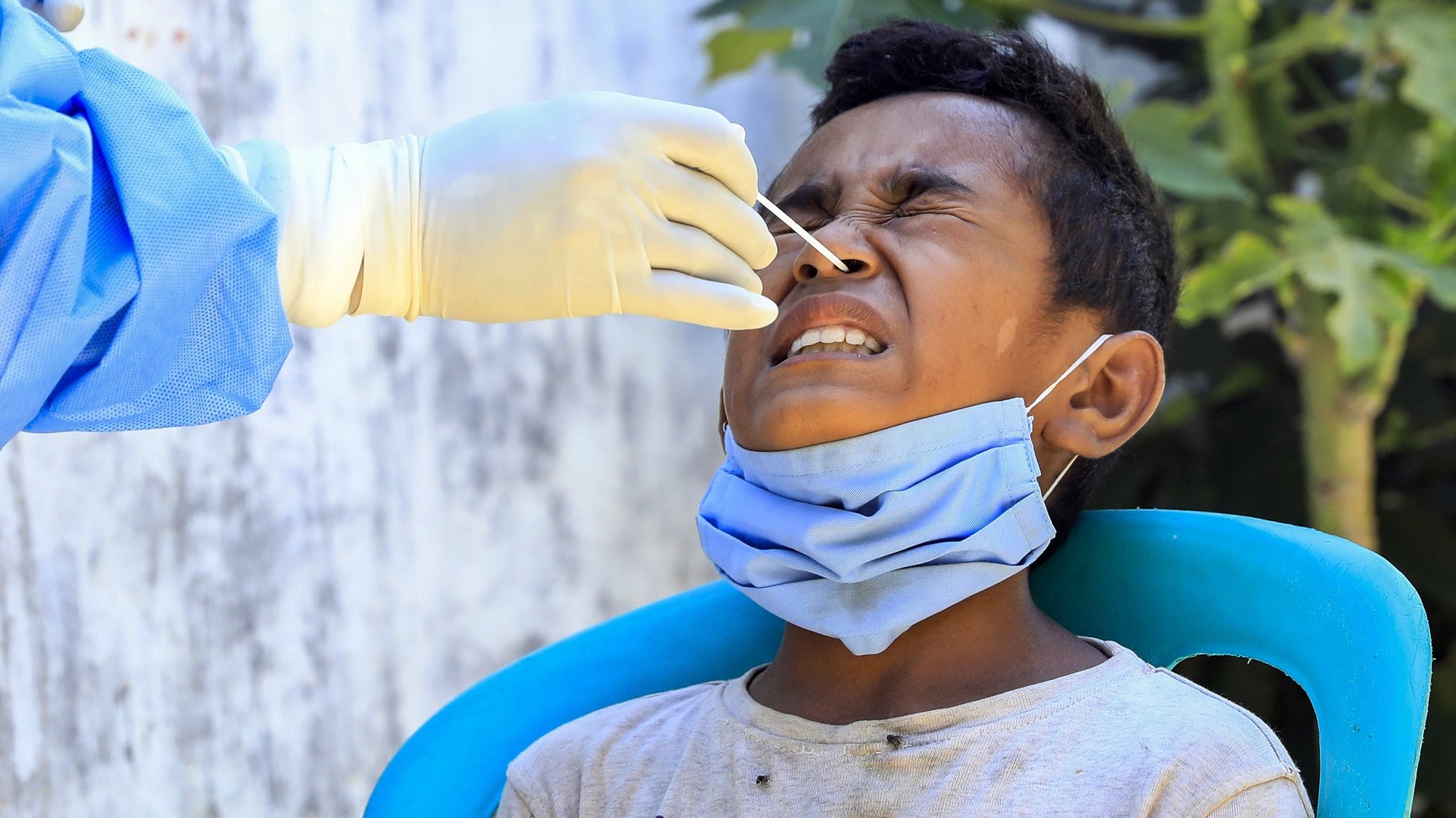 epa09079361 A boy reacts as a healthcare worker collects his specimen samples during a COVID-19 swab test in Dili, East Timor, also known as Timor Leste, 17 March 2021. With less than 300 COVID-19 cases and zero deaths, Timor Leste recorded the second-smallest outbreak in Southeast Asia after Laos. The country imposed a state of emergency a week after the Catholic-majority nation reported its first case on 21 March 2020, and enforced strict border controls.  EPA/ANTONIO DASIPARU