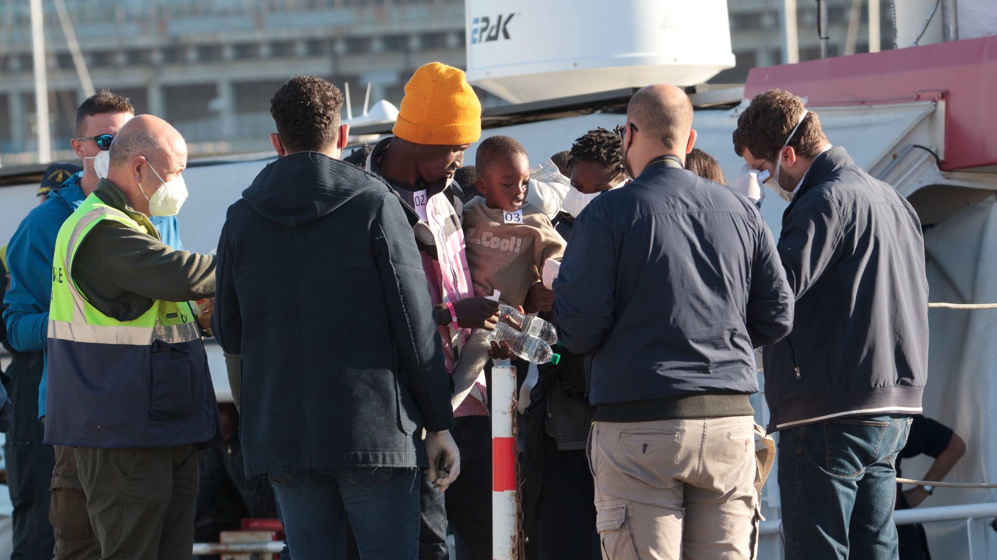 epa10293267 Some of the 89 migrants who were onboard the Rise Above ship arrive at the port of Reggio Calabria, Italy, 08 November 2022. The ship was escorted by two patrol boats from the Guardia di Finanza and the Harbor Master&#039;s Office. The landing operations of the 89 migrants on board will soon begin.  EPA/MARCO COSTANTINO