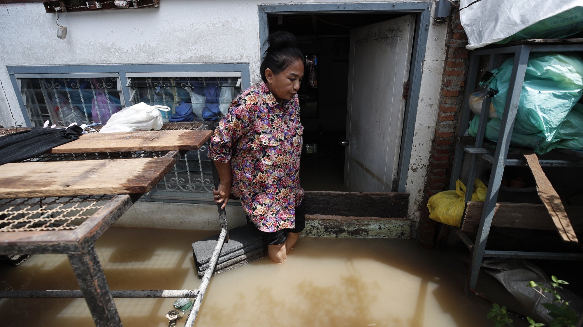 epa09506891 A Thai villager leaves her flooded house at a community in Koh Kret, Nonthaburi neighboring province of Bangkok, Thailand, 05 October 2021. Flooding caused by tropical storm Dianmu has swamped 32 provinces in several parts of Thailand, killed at least eight people and more than two hundreds thousands households have been affected, according to the Disaster Prevention and Mitigation Department.  EPA/RUNGROJ YONGRIT