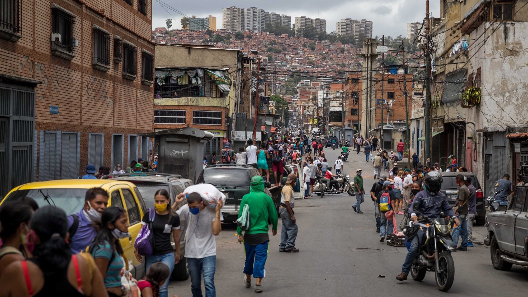 epa08547644 Dozens of people walk down a street in the Catia sector, in Caracas, Venezuela, 14 July 2020 (issued 15 July). Venezuela has been in coronavirus crisis mode for four months.  EPA/MIGUEL GUTIERREZ