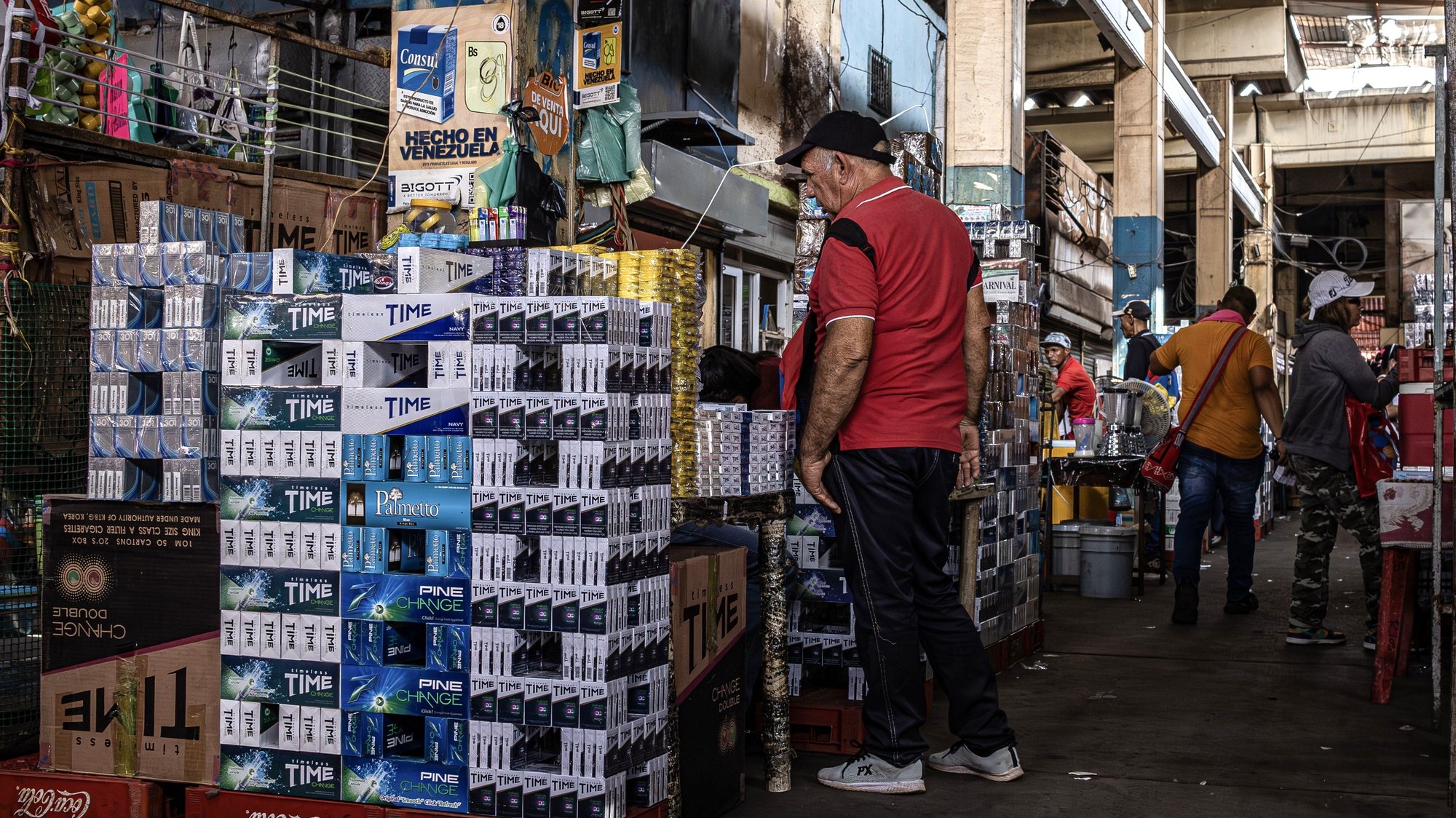 epa11246938 A man stands next to cigarette packets  stacked at a market in Maracaibo, northwestern Venezuela, 22 March 2024 (issued 27 March 2024). Venezuela&#039;s tobacco industry and the authorities are waging a battle against contraband, its main competitor, which peaked at 44 percent of the domestic market a year ago, according to independent estimates, with repercussions on business and state revenues.  EPA/HENRY CHIRINOS