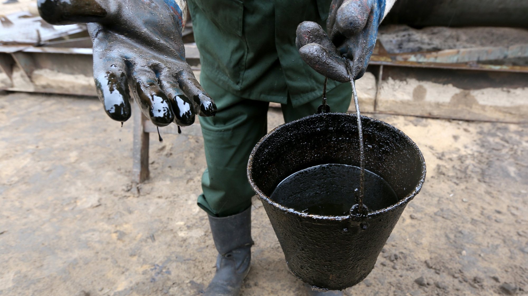 epa05986874 A worker of Belarusian scientific production center of geology shows a newly extracted Belarusian mineral oil at the reconnaissance oil well near the village of Dobrogoshcha, some 210 km from Minsk, Belarus, 24 May 2017. Belarus continues to conduct oil exploration on its territory.  EPA/TATYANA ZENKOVICH