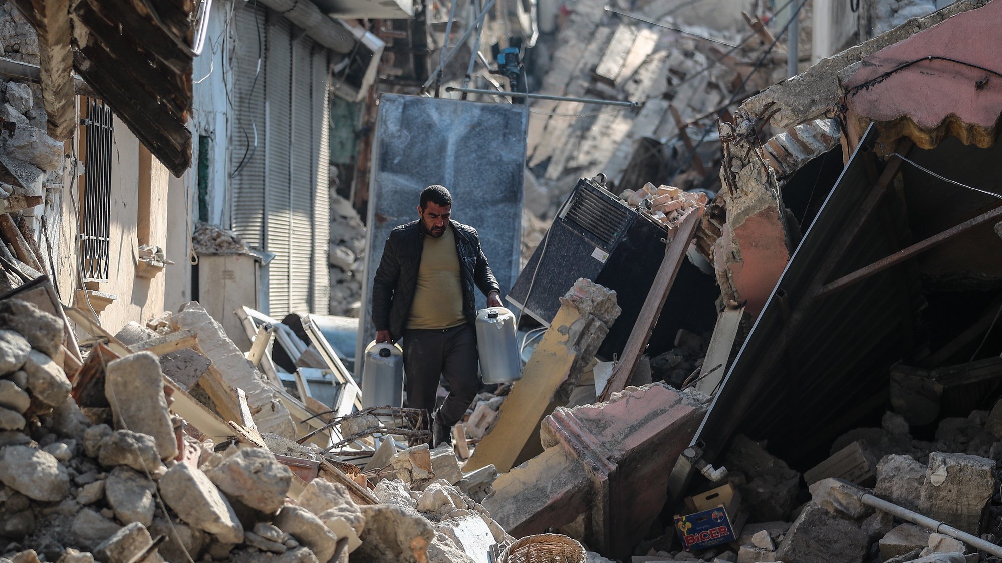 epaselect epa10485019 A man walks among the rubble of collapsed buildings in the aftermath of powerful earthquakes in Hatay, Turkey, 23 February 2023. More than 46,000 people died and thousands more were injured after major earthquakes struck southern Turkey and northern Syria on 06 February and again on 20 February.  EPA/ERDEM SAHIN