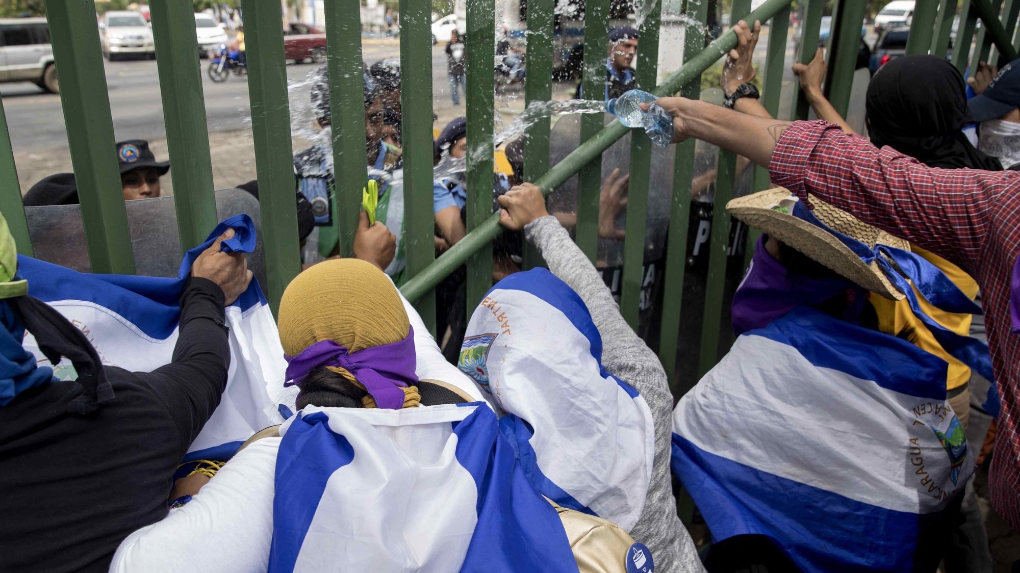 epa08010133 Students throw water at riot agents during a protest demanding the release of political prisoners at the Universidad Centroamericana (UCA), in Managua, Nicaragua 19 November 2019.  EPA/Jorge Torres