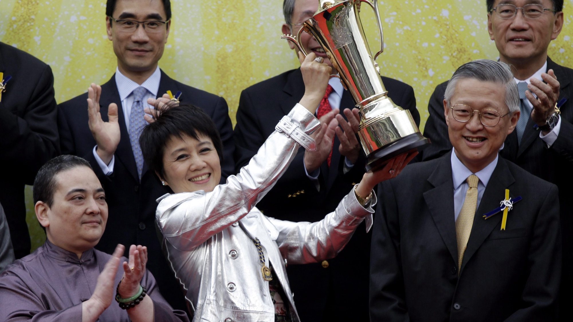 epa02131016 Horse owner Macau tycoon Stanley Ho&#039;s wife Angel (C) a showiing the trophy after hre horse Viva Pataca won the QEII Cup at the Shatin race track, during the horse races in Hong Kong, China 25 April 2010.  EPA/YM YIK
