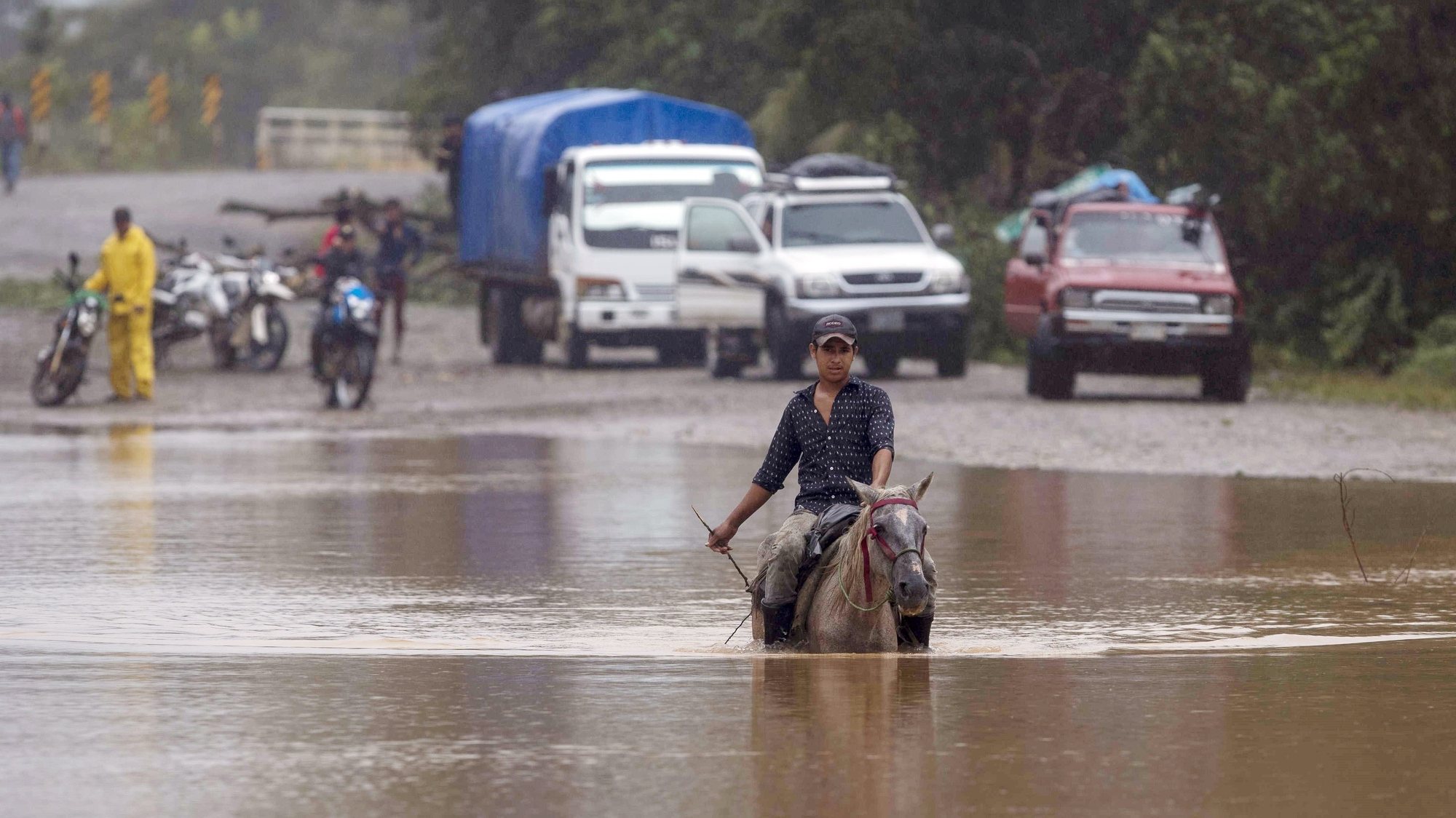 epa08798473 A farmer mounted on his horse crosses a flooded road in the Okonwas community during the passage of Hurricane Eta on the north Caribbean coast in Rosita, Nicaragua, 04 November 2020. The dangerous hurricane Eta, which made landfall in Nicaragua this Tuesday as a category 4, weakened to a tropical storm, but is still expected to cause problems in parts of Central America, before leaving for the Caribbean again.  EPA/JORGE TORRES