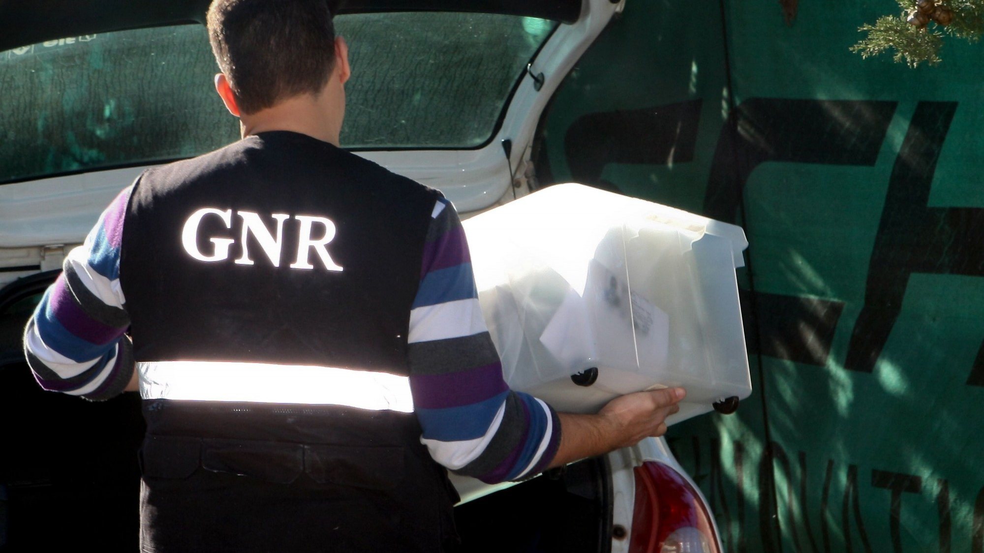 Um elemento da GNR transporta material apreendido durante uma operação em Almancil com rusgas a casas de suspeitos de tráfico de droga