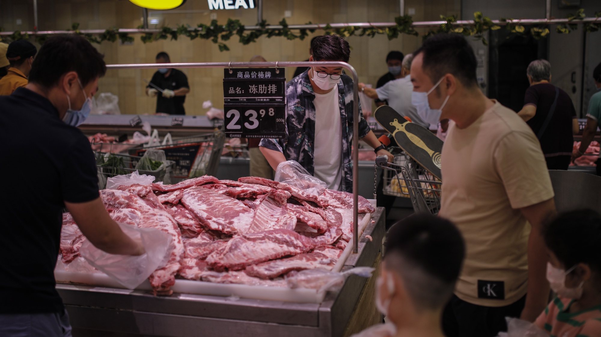 epa08507965 People wearing protective face masks select pork chops in a supermarket on the Chinese traditional holiday of Dragon Boat Festival, amid coronavirus pandemic in Beijing, China, 25 June 2020.  EPA/WU HONG