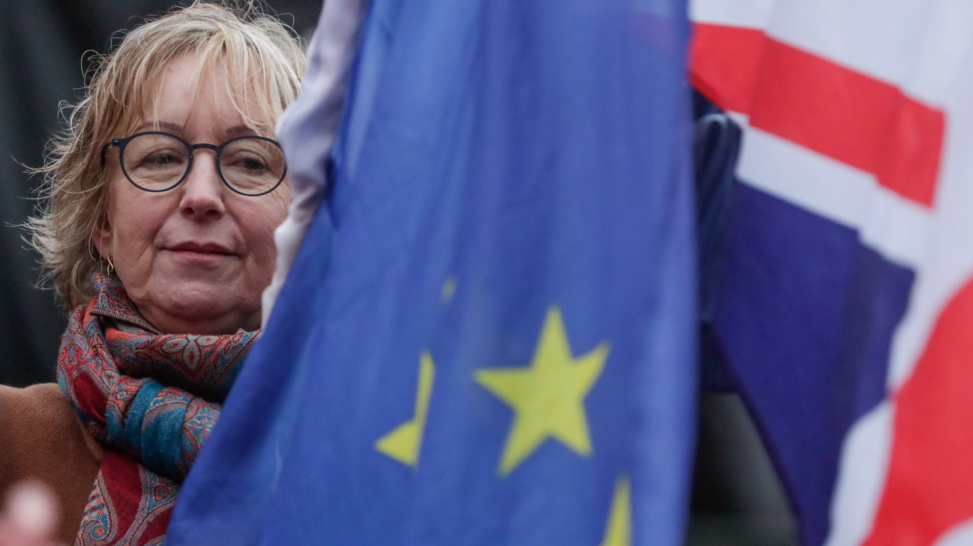 epa08179430 A woman holds a European flag and a Union Jack flag on the Grand Place in Brussels, Belgium, 30 January 2020. The city of Brussels is organizing the &#039;Brussels Calling&#039; event to underline its long friendship with the British. The UK will leave the EU on 31 January 2020.  EPA/STEPHANIE LECOCQ