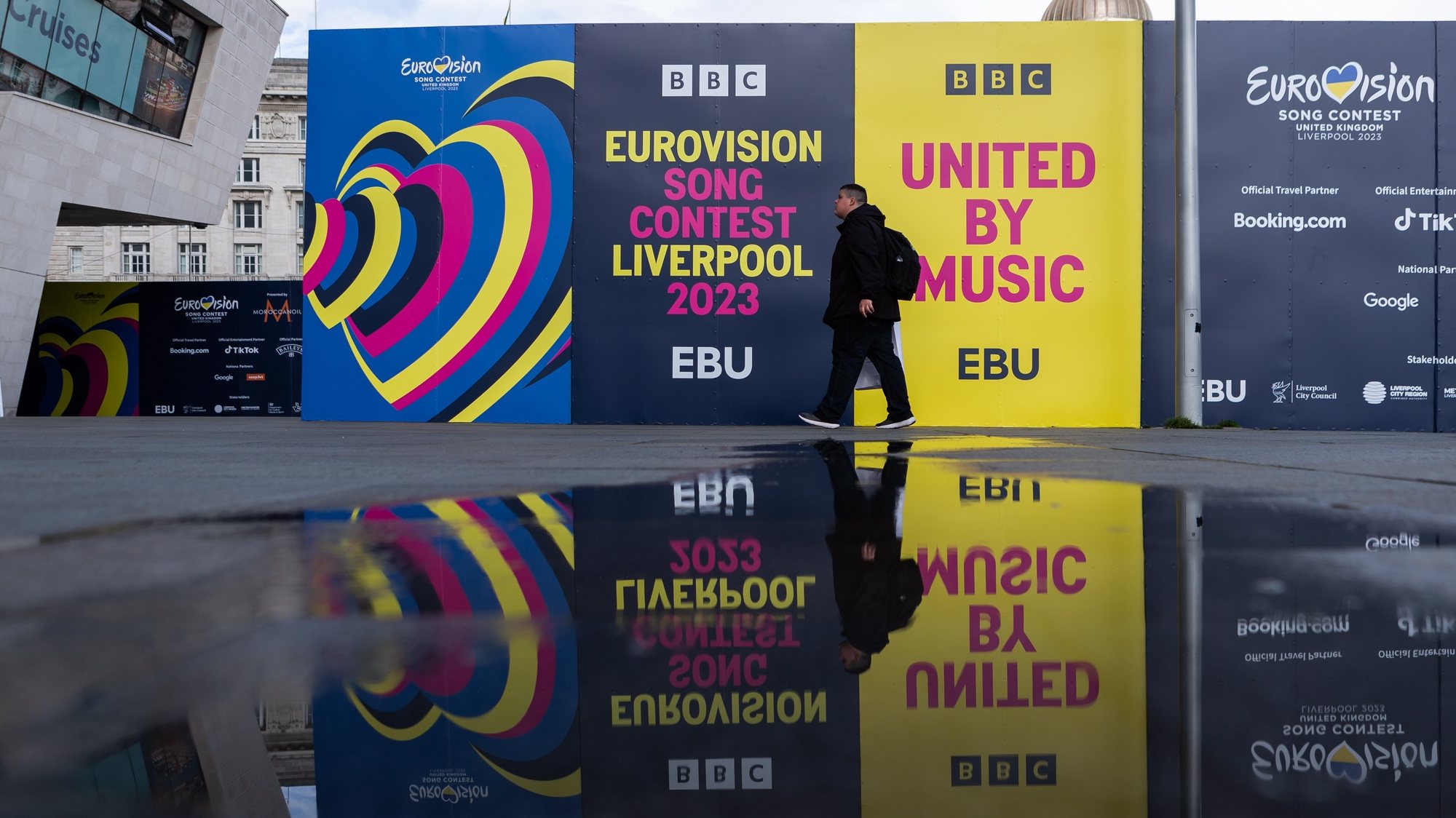 epa10610780 A person walks past Eurovision signs at the Pier Head in Liverpool, Britain, 05 May 2023. Liverpool is preparing to host the 2023 Eurovision Song Contest on behalf of Ukraine. The 67th edition of the Eurovision Song Contest (ESC) consists of two Semi-Finals, held on 09 and 11 May, and a Grand Final on 13 May 2023.  EPA/ADAM VAUGHAN