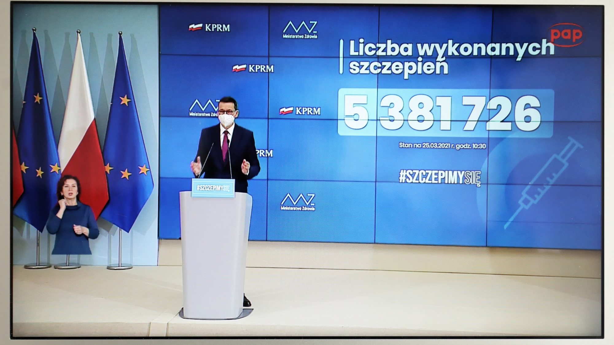 epa09095668 A television screen shows Polish Prime Minister Mateusz Morawiecki during a press conference on the coronavirus pandemic situation in Warsaw, Poland, 25 March 2021. In all, 5,381,726 Poles have already received jabs against COVID-19, with 1,857,517 of those having had both doses of the vaccine, according to data posted on the official government website.  EPA/Pawel Supernak POLAND OUT