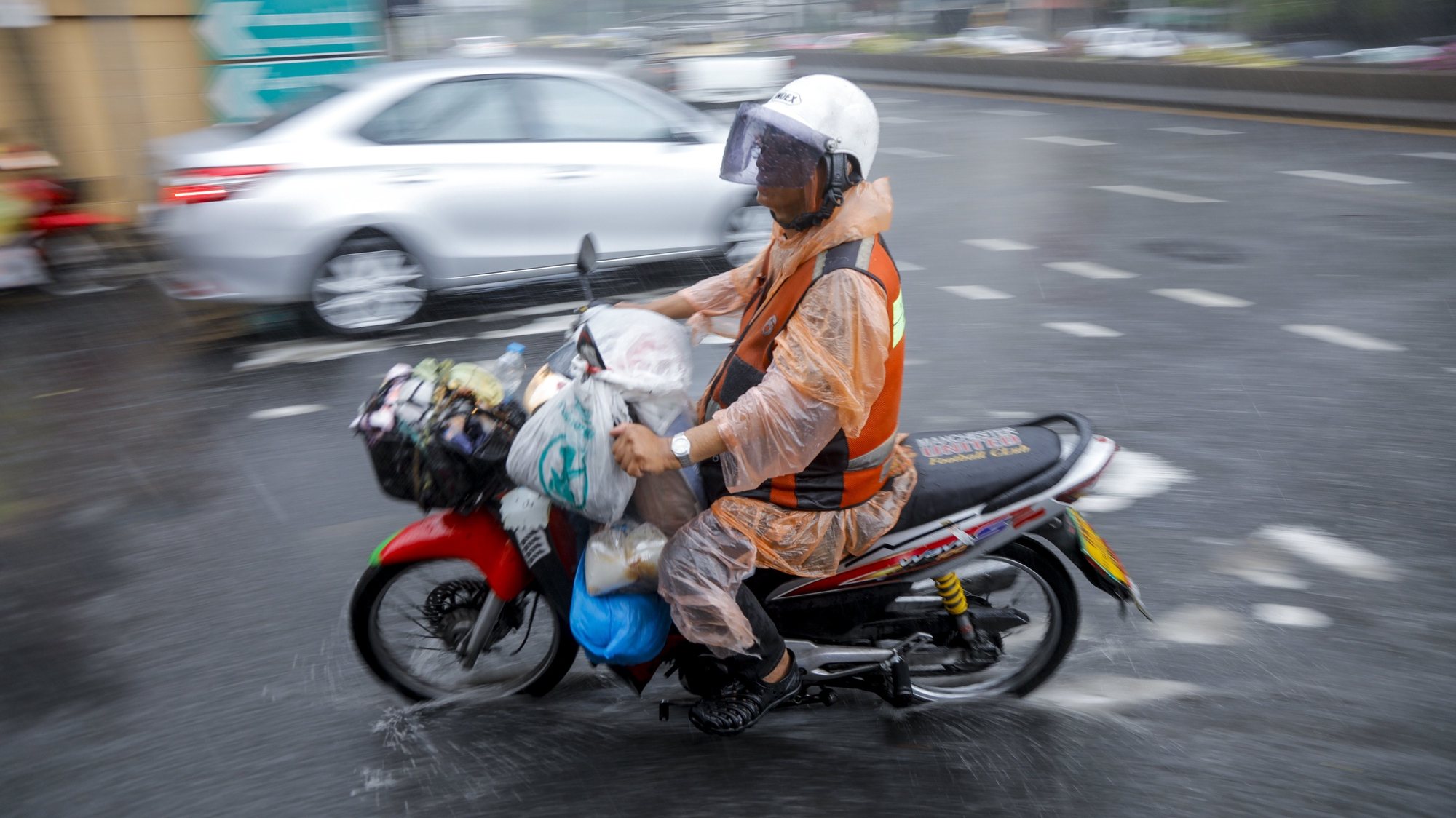 epaselect epa05969493 A motorcycle taxi drives through a puddle of rain water during heavy summer storm in Bangkok, Thailand, 17 May 2017. Thailand&#039;s Meteorological Department warned of heavy to very heavy rain in upper Thailand as well as a strong wind wave in the Andaman Sea.  EPA/DIEGO AZUBEL