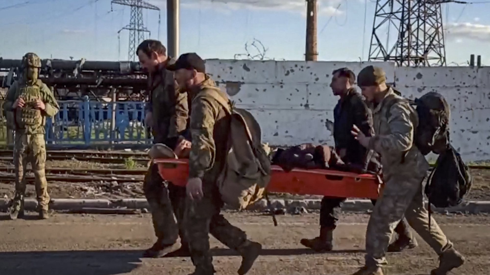 epa09952378 A handout still image taken from a handout video made available by the Russian Defence Ministry&#039;s press service shows Ukrainian servicemen carry a wounded comrade as they are being evacuated from the besieged Azovstal steel plant in Mariupol, Ukraine, 17 May 2022. A total of 265 Ukrainian militants, including 51 seriously wounded, have laid down arms and surrendered to Russian forces, the Russian Ministry of Defence said on 17 May 2022. Those in need of medical assistance were sent for treatment to a hospital in Novoazovsk, the ministry states further. Russian President Putin on 21 April 2022 ordered his Defence Minister to not storm but to blockade the plant where a number of Ukrainian fighters were holding out. On 24 February, Russian troops invaded Ukrainian territory starting a conflict that has provoked destruction and a humanitarian crisis. According to the UNHCR, more than six million refugees have fled Ukraine, and a further 7.7 million people have been displaced internally within Ukraine since.  EPA/RUSSIAN DEFENCE MINISTRY PRESS SERVICE HANDOUT  BEST QUALITY AVAILABLE HANDOUT EDITORIAL USE ONLY/NO SALES