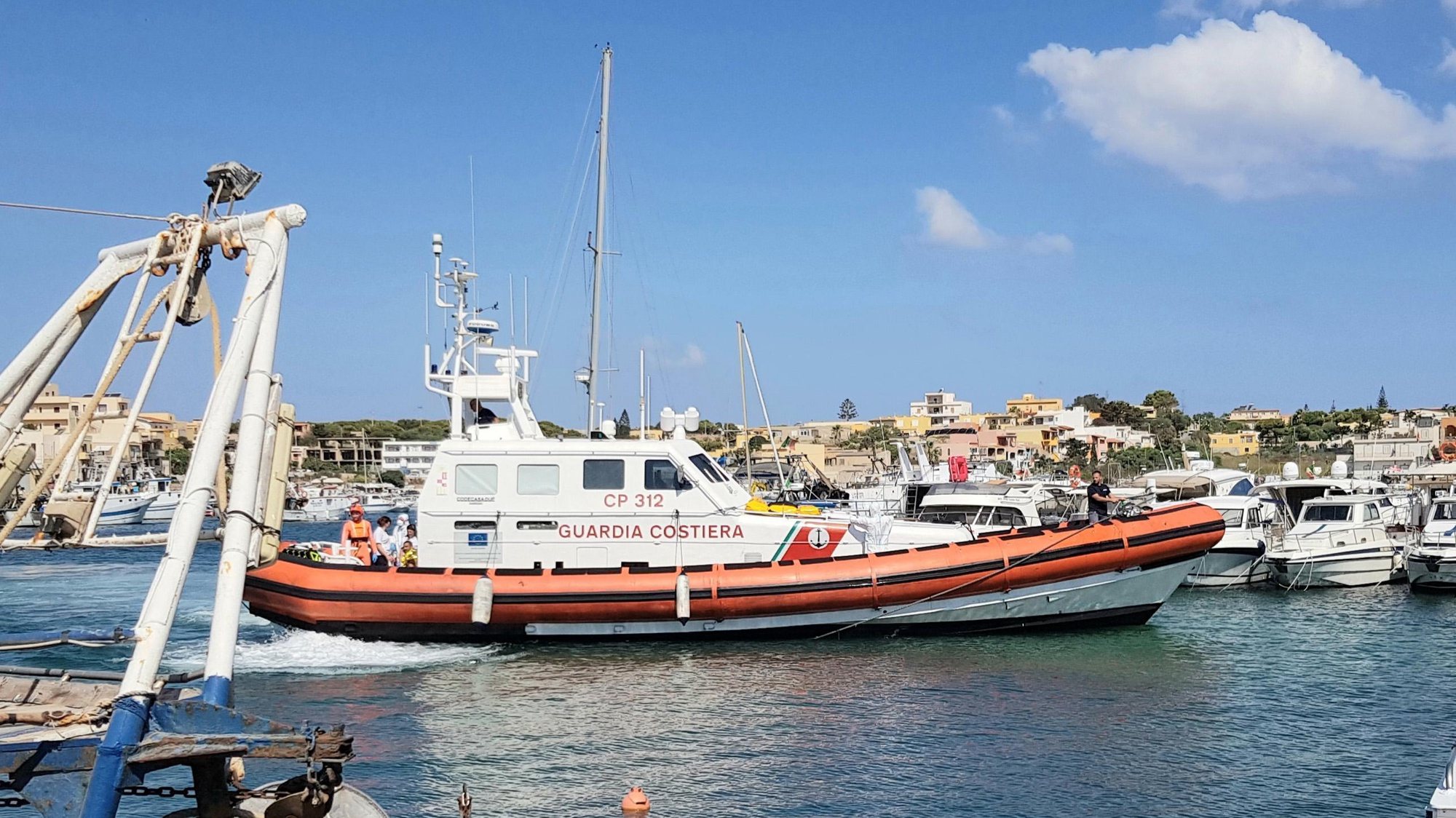 epa07781779 An Italian Coast Guard patrol boat carrying a migrant who reportedly dived into the sea from the Spanish NGO rescue ship Open Arms in an attempt to swim to the coast, arrives in Lampedusa, southern Italy, 20 August 2019. The Open Arms ship is anchored at about 800 meters from the rocks of Lampedusa Island. The man was recovered by the Coast Guard patrol boat.  EPA/ELIO DESIDERIO