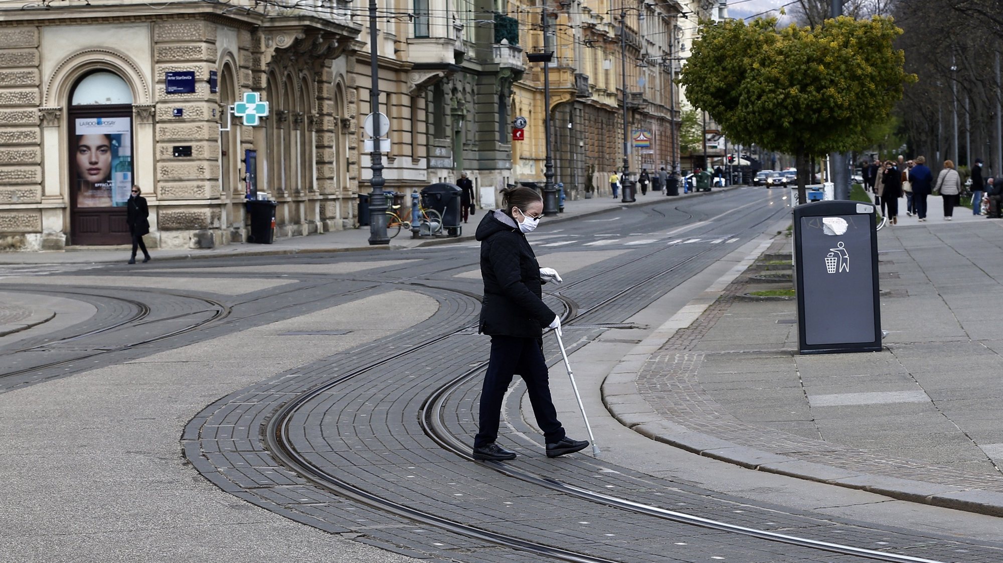epa09152234 A woman wearing face mask on a street in Zagreb, Croatia, 22 April 2021. Health authorities in Croatia said covid-19 daily new infections recorded 2,885 people and 46 related deaths.  EPA/ANTONIO BAT