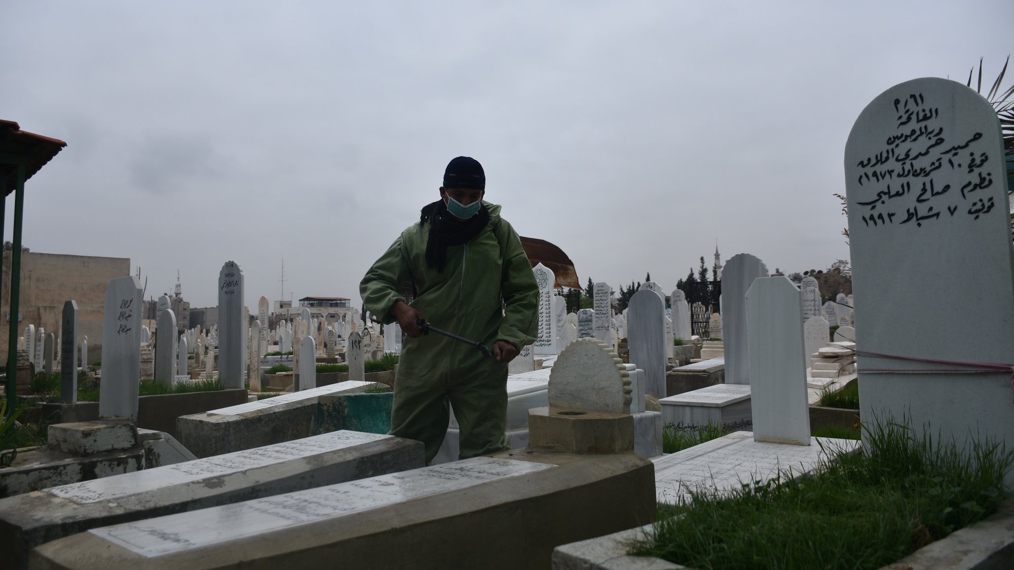 epa08908954 Workers of the Syrian municipality department sterilize tombs in a cemetery in Damascus, Syria, on 29 December 2020. The campaign is part of the governmentâ€™s efforts to prevent further spreading of COVID-19.  EPA/YOUSSEF BADAWI