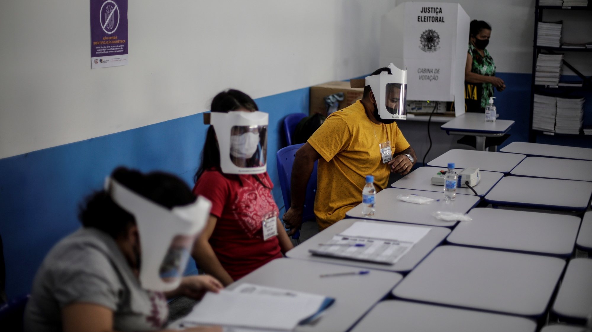 epa08821830 Election workers wait for voters at a polling station during local election in Rio de Janeiro, Brazil, 15 November 2020. Voters are to elect mayors and councelmen  in some 5,596 Brazilian towns for next four years.  EPA/Antonio Lacerda