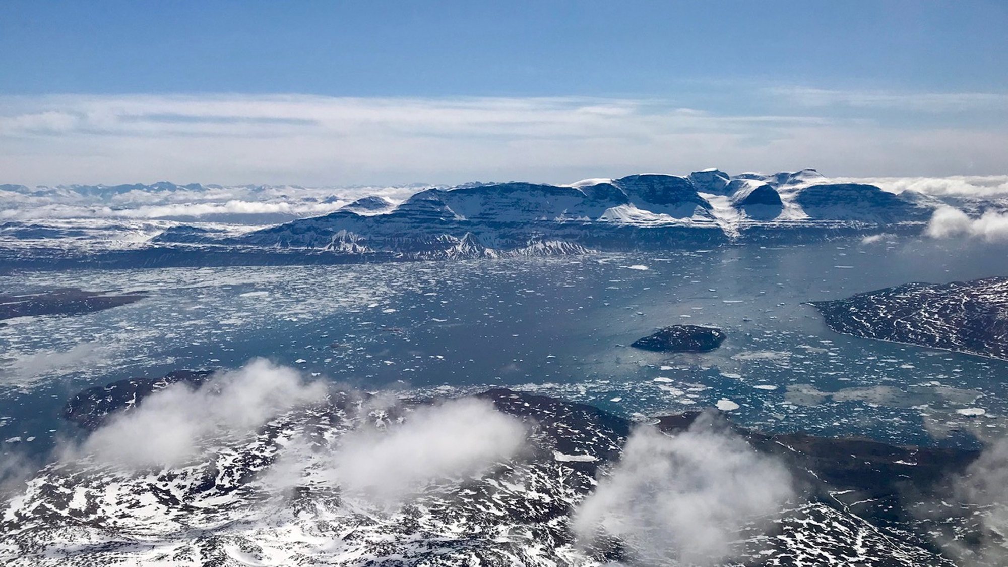 epa06730116 A handout photo made available by NASA on 12 May 2018 shows small puffy cumulus clouds in the foreground, with sea ice, open water and a fjord wall in the background in southern Greenland, 29 April 2018, seen during an operation IceBridge survey flight. Operation IceBridge is NASA&#039;s longest-running airborne mission to monitor polar ice change. This year&#039;s springtime survey of Arctic sea and land ice began on 22 March and will conclude on 02 May. The flights covered the western basin of the Arctic Ocean and Greenland&#039;s fastest-changing glaciers.  EPA/NASA/LINETTE BOISVERT HANDOUT  HANDOUT EDITORIAL USE ONLY/NO SALES